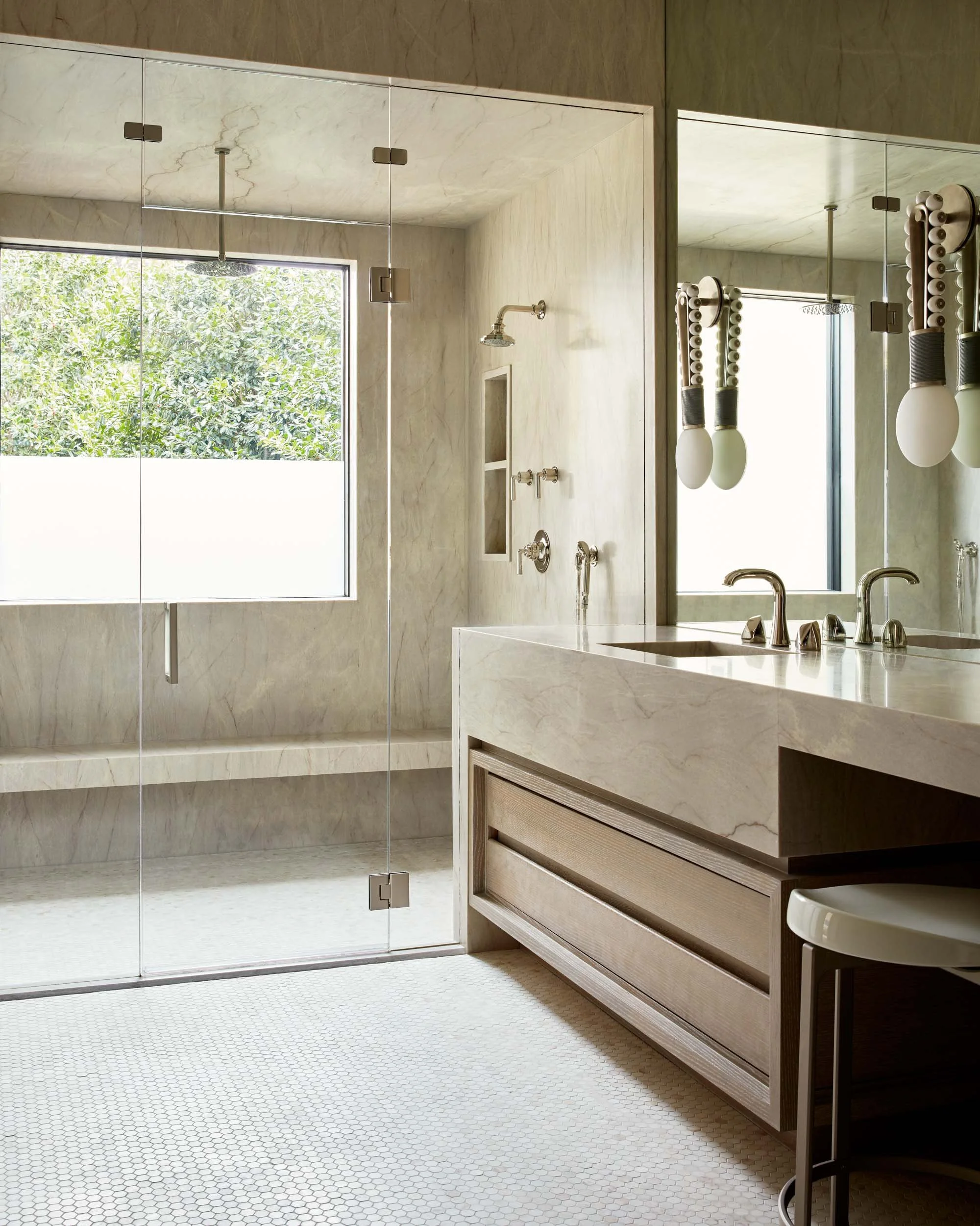  Bathroom countertops and shower walls with light fixtures.  