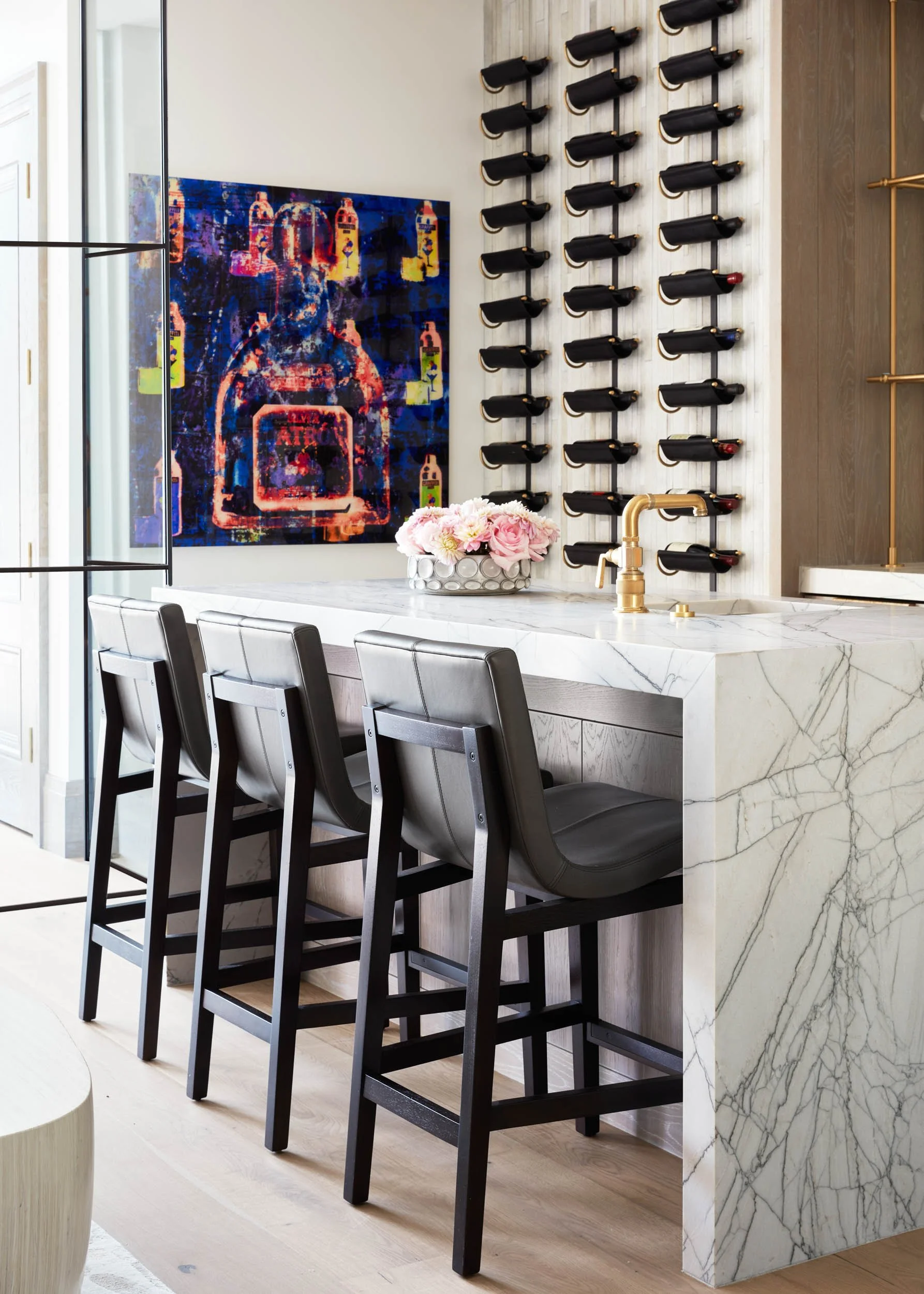  Bar area with dark brown chairs, marble countertops and other decor items.  