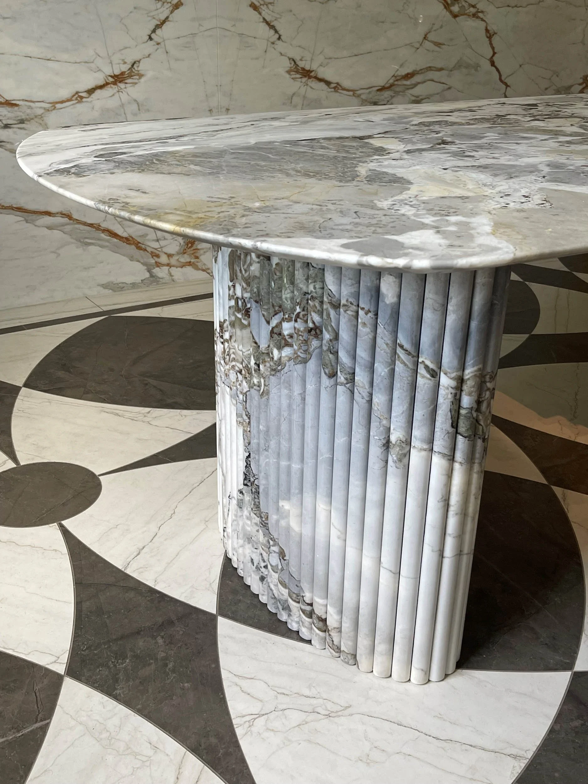  Up close shot of a tabletop and leg made out of fluted marble. 