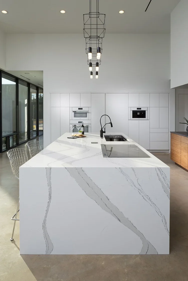  Kitchen countertops with light fixtures and white walls.  