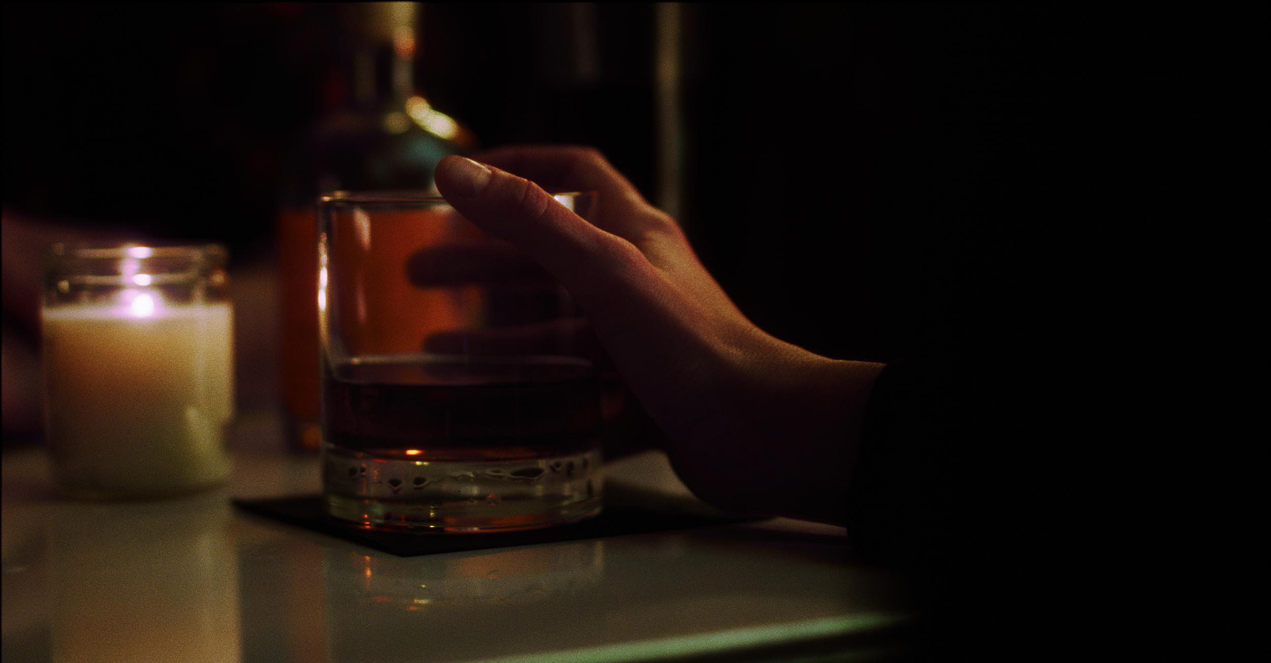 A hand around a whiskey glass, from The Cricket at the Bottom of the Glass