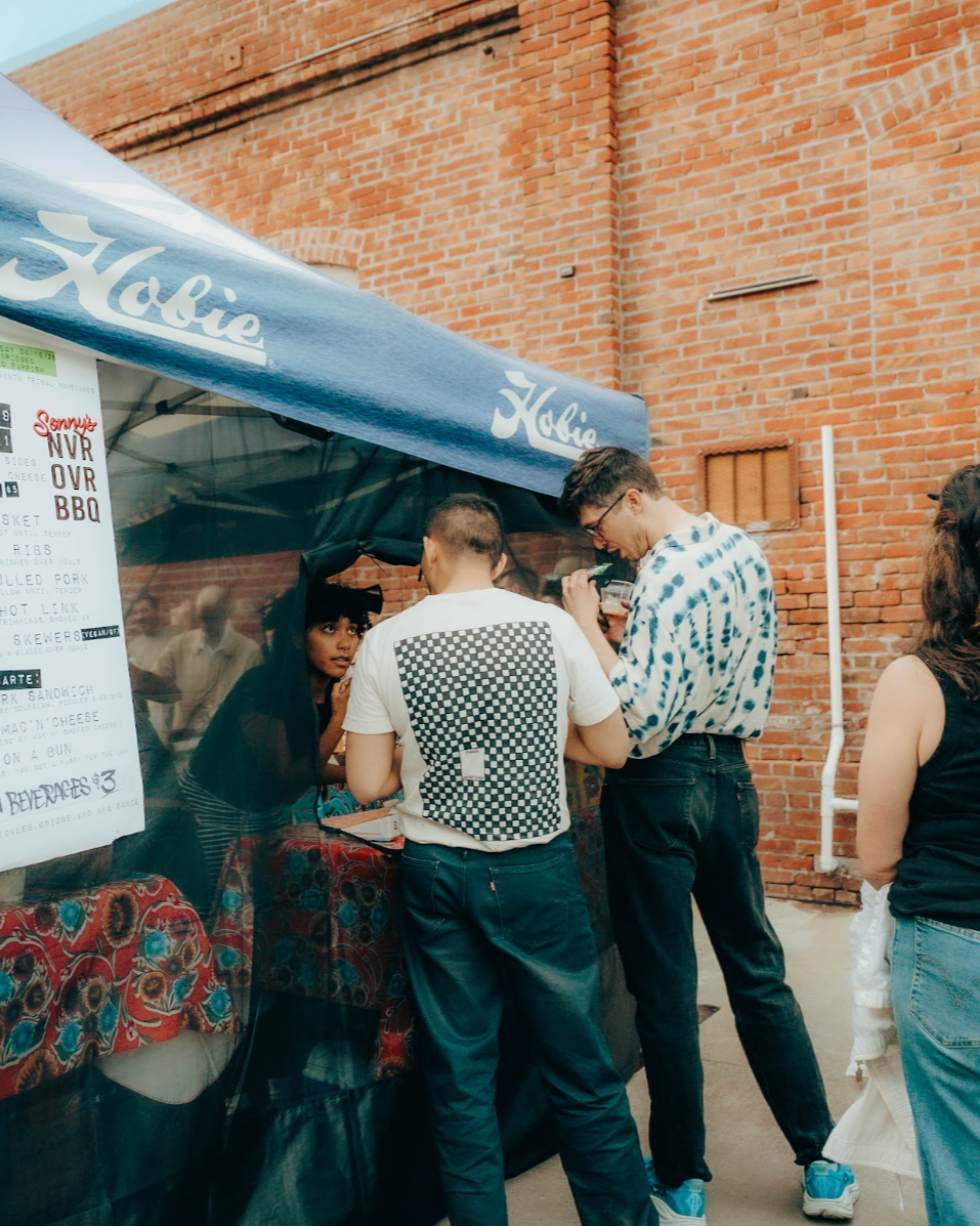 Customer ordering NVR OVR BBQ vendor at an outdoor event at The Loom