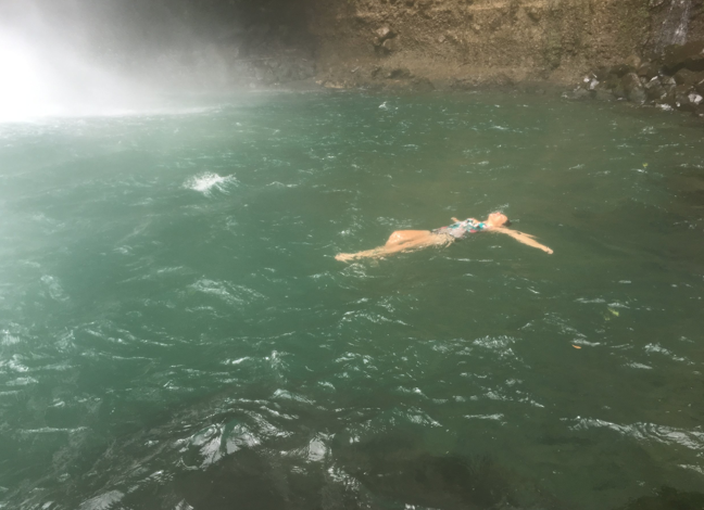 Woman Swims in a Waterfall
