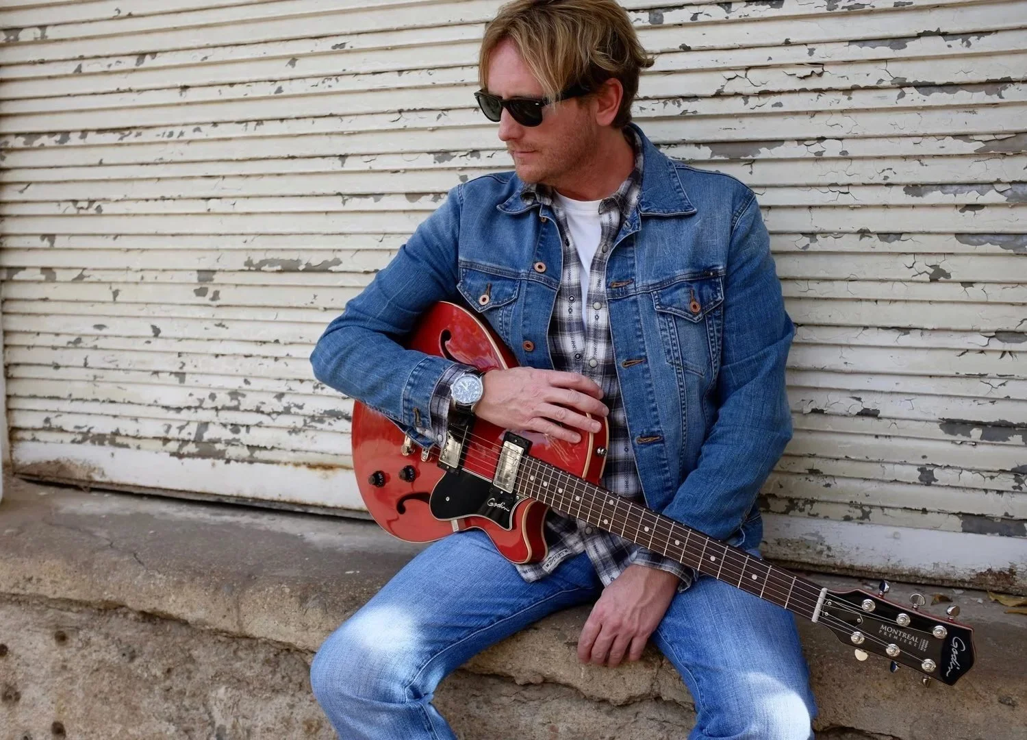 Promotional portrait of American singer-songwriter Scott Helmer with a red electric guitar.