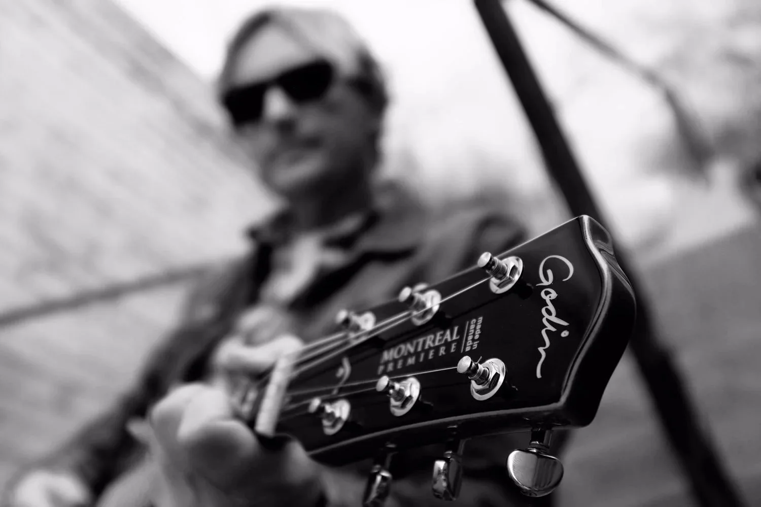 Close-up promotional portrait of American singer-songwriter Scott Helmer with a Godin guitar.