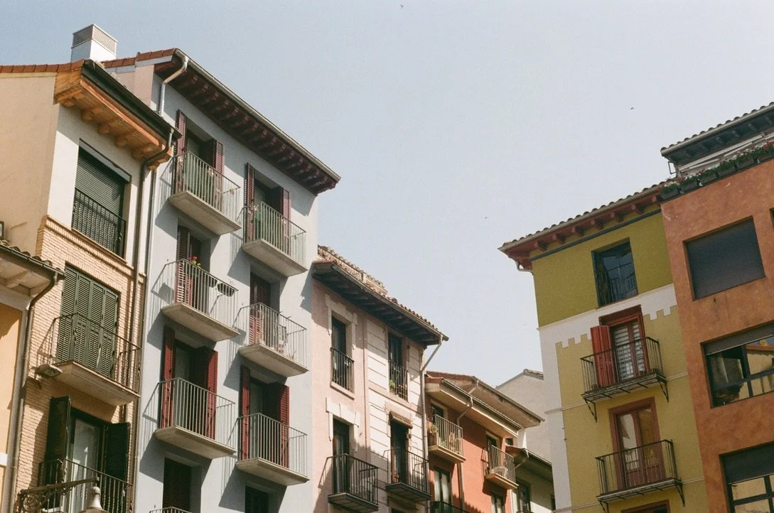 Colorful apartment buildings with balconies under a clear sky.