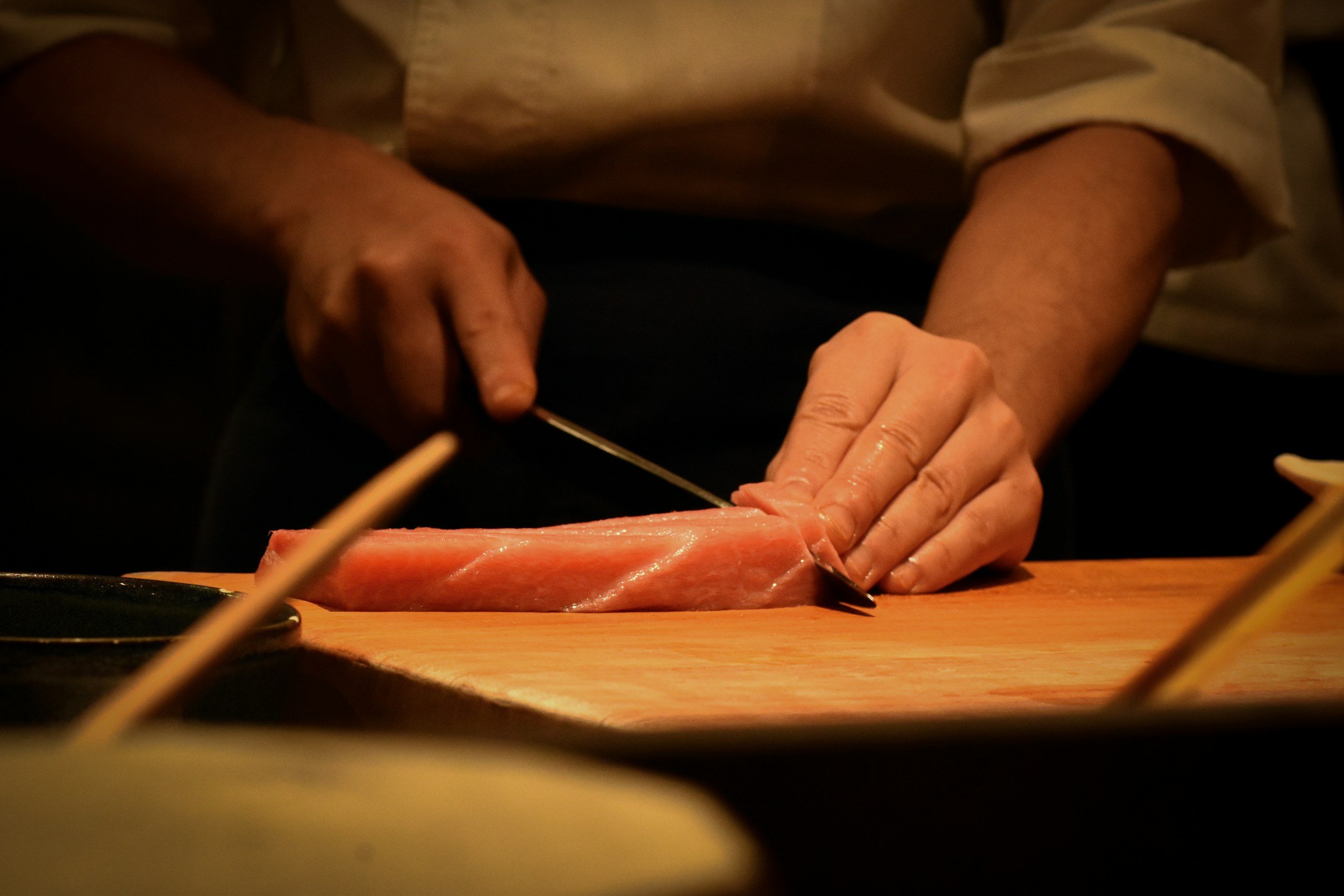 Fresh cut of tuna being cut by sushi chef