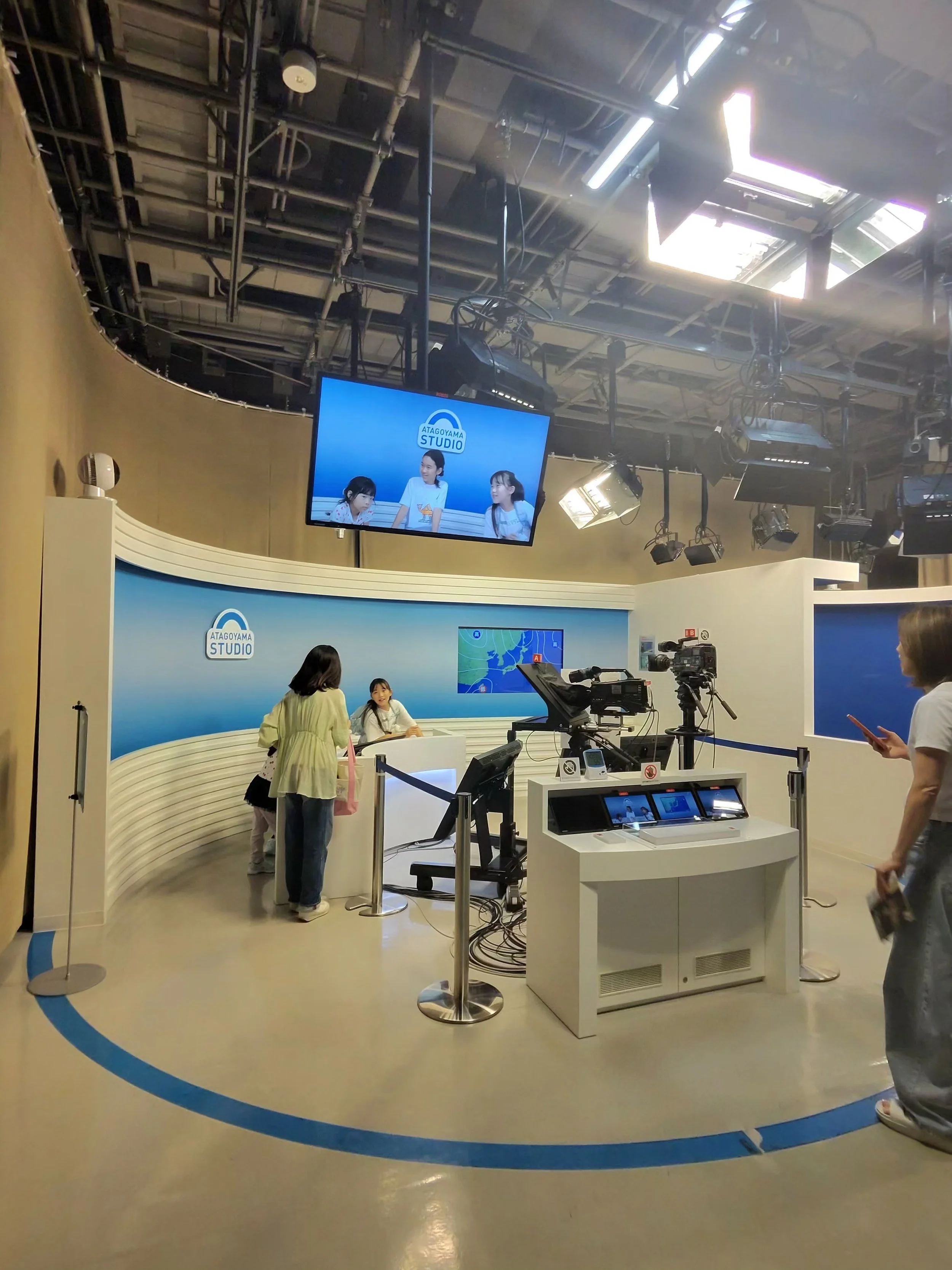 Visitors exploring the interactive television studio exhibit at the NHK Museum of Broadcasting in Tokyo.