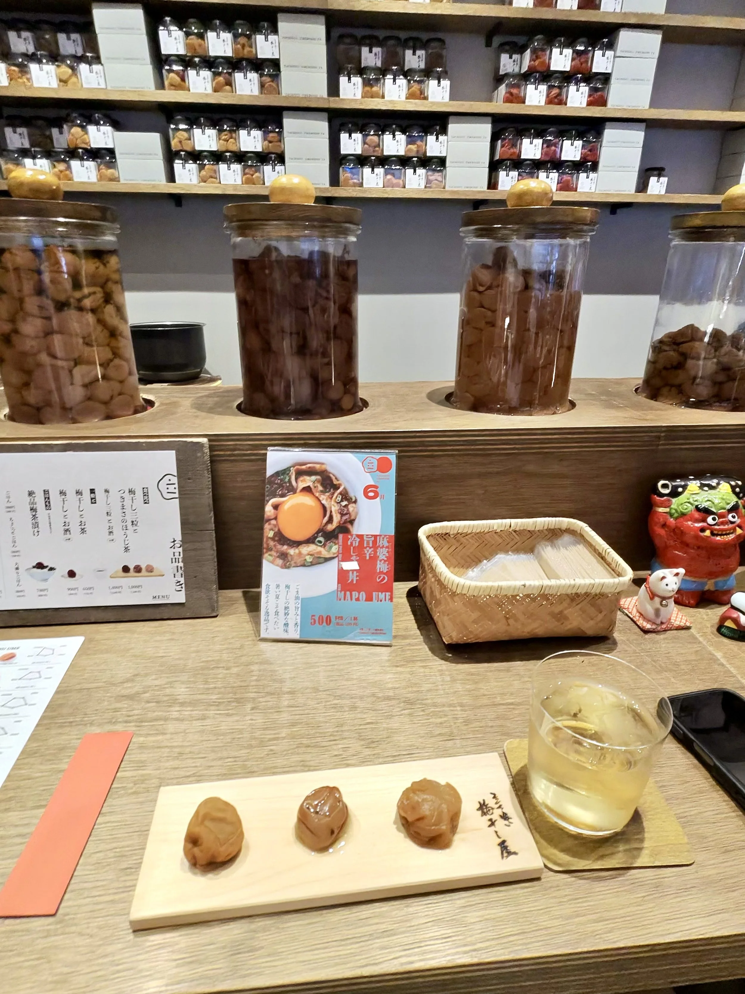 Umeboshi tasting at Tachigui Umeboshi-ya in Tokyo featuring three varieties of Japanese pickled plums served with tea. Visitors can compare different flavors before selecting their favorite umeboshi.