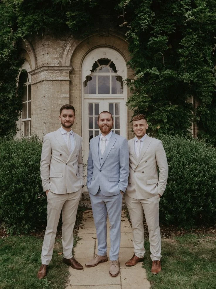 Groom In Blue Wedding Suit with Groomsmen in Matching Cream Suits.jpeg