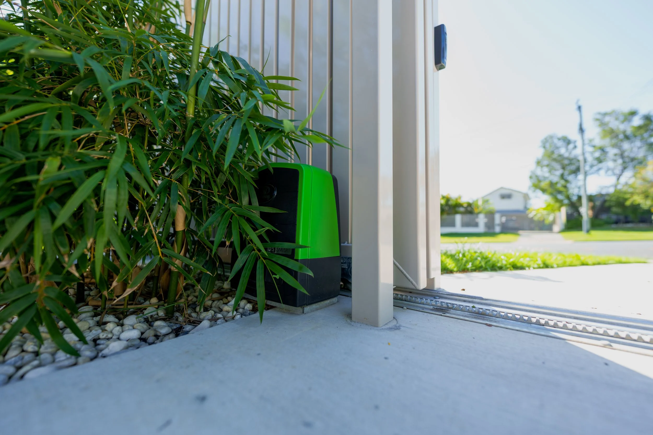 Automatic sliding gate motor installed beside a residential driveway gate