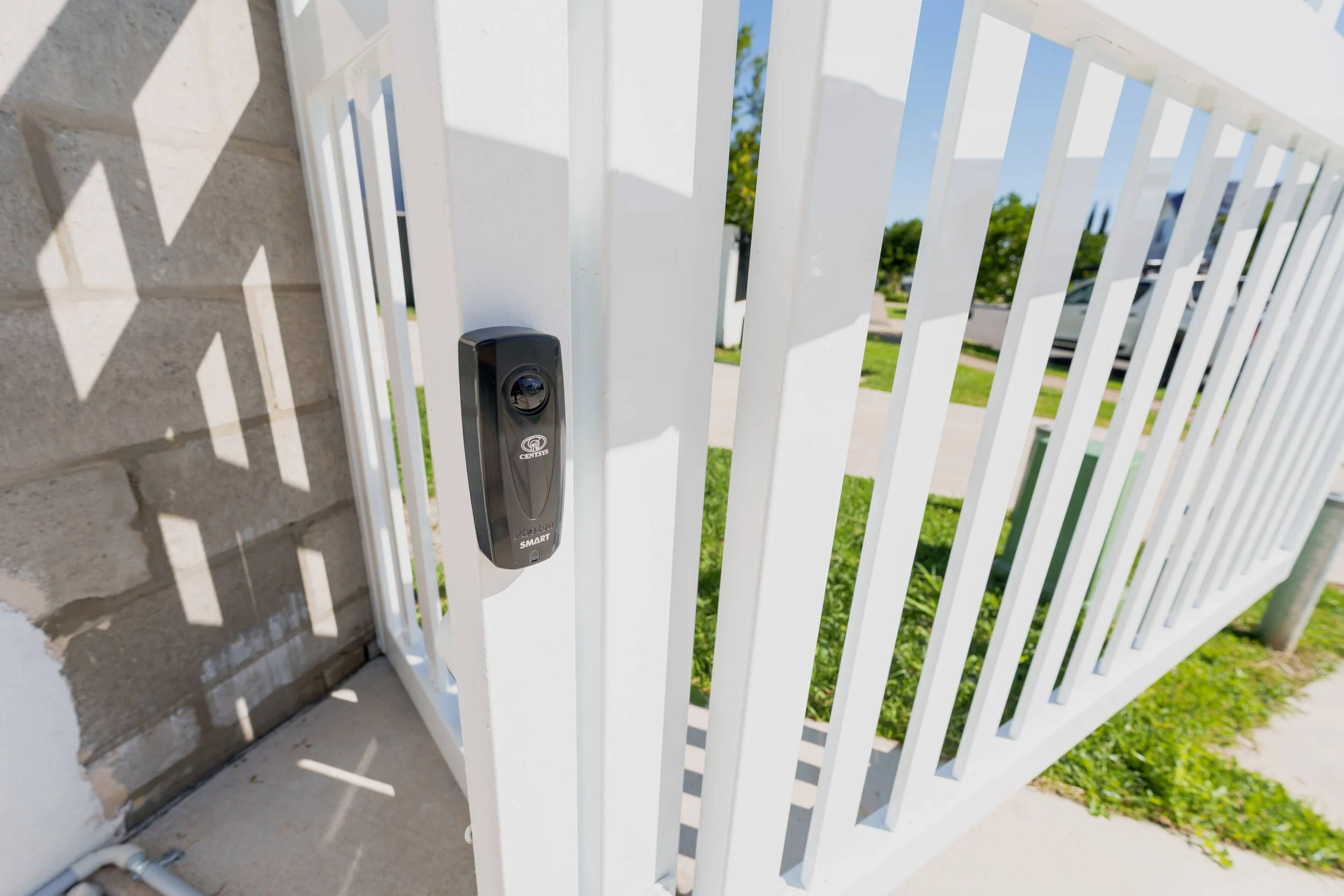 Access control hardware fitted to a white pedestrian gate