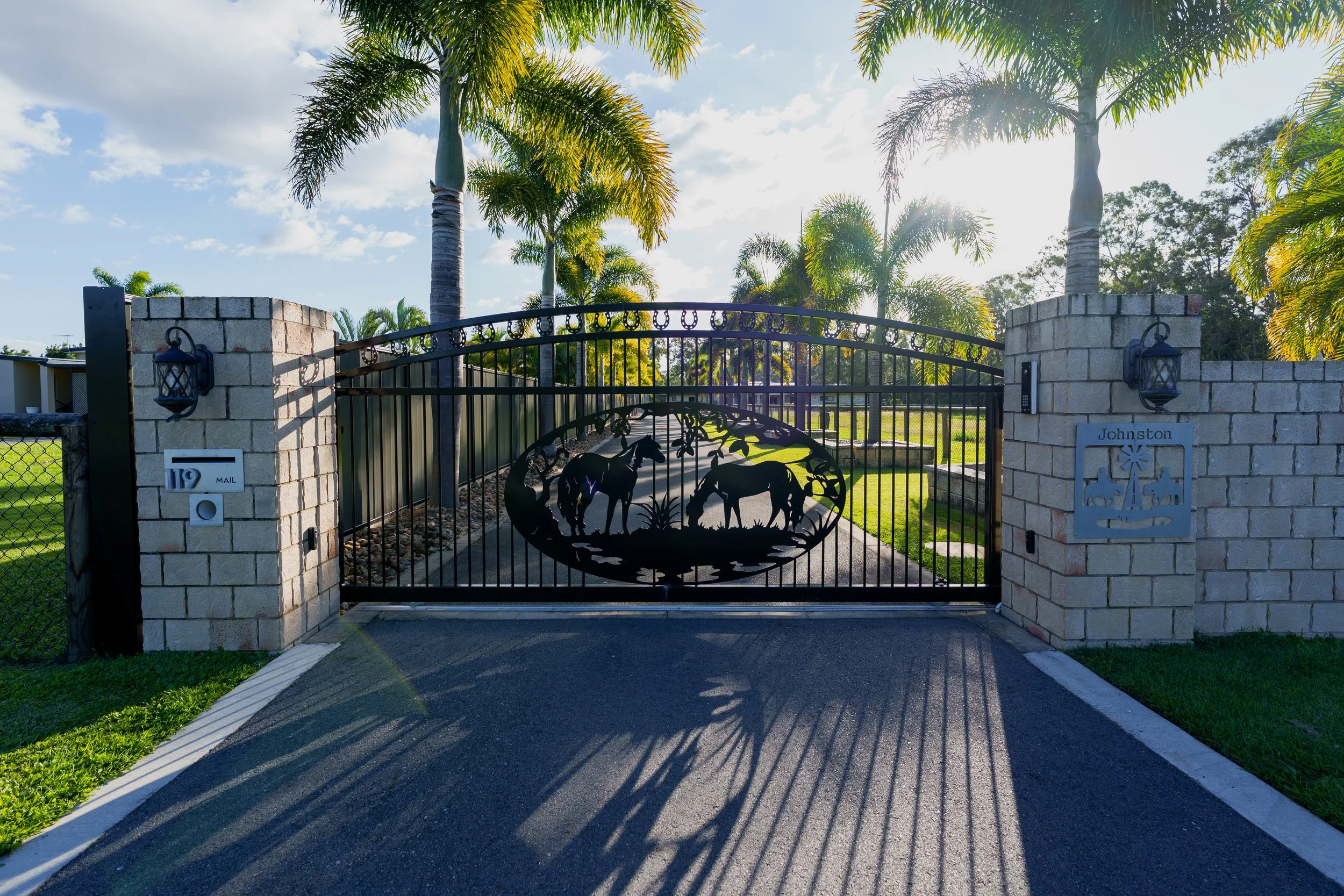 Decorative black driveway gate with horse silhouette panels