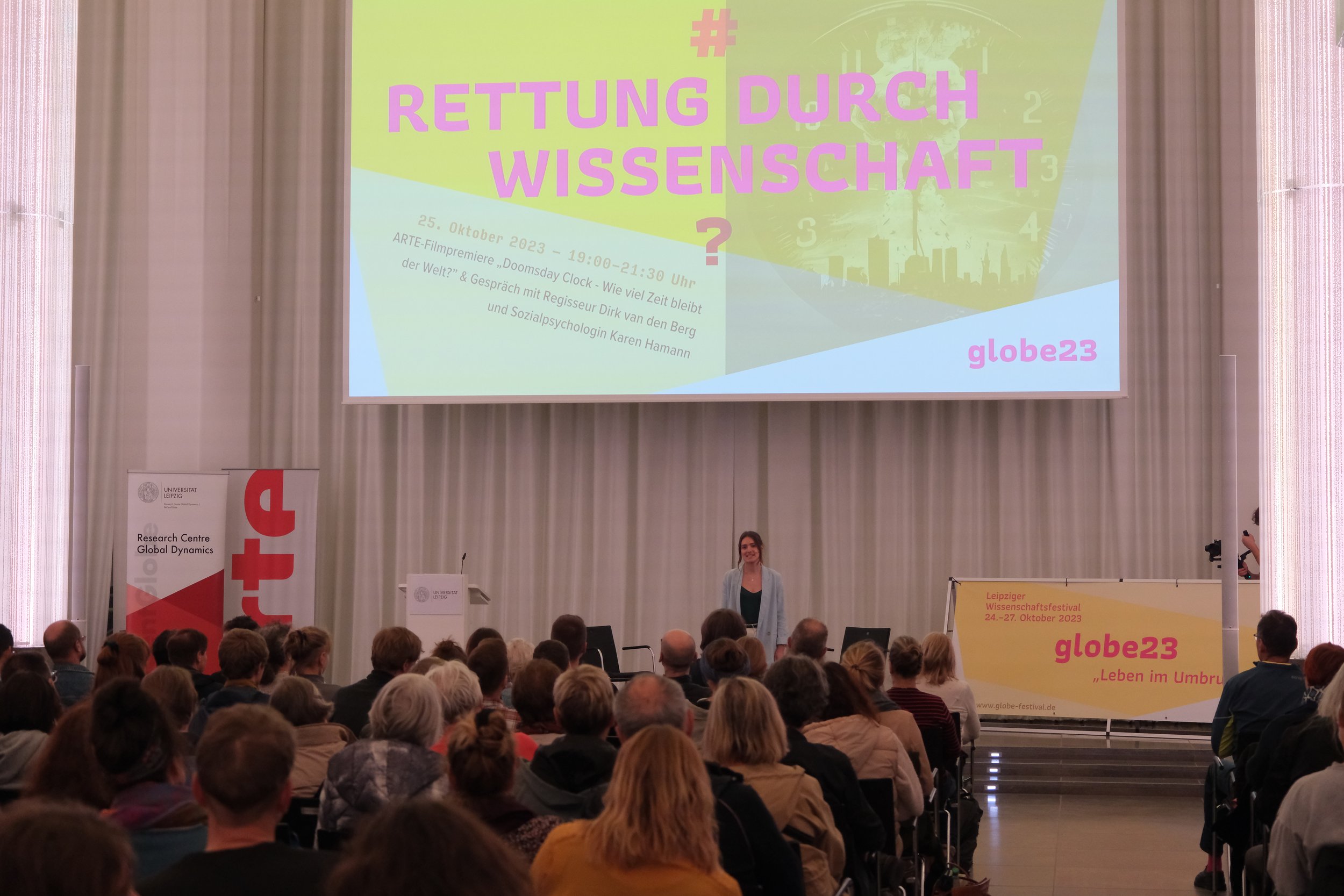 Moderatorin Dayala Lang vor versammeltem Publikum. Foto: Florian Förster/Universität Leipzig.