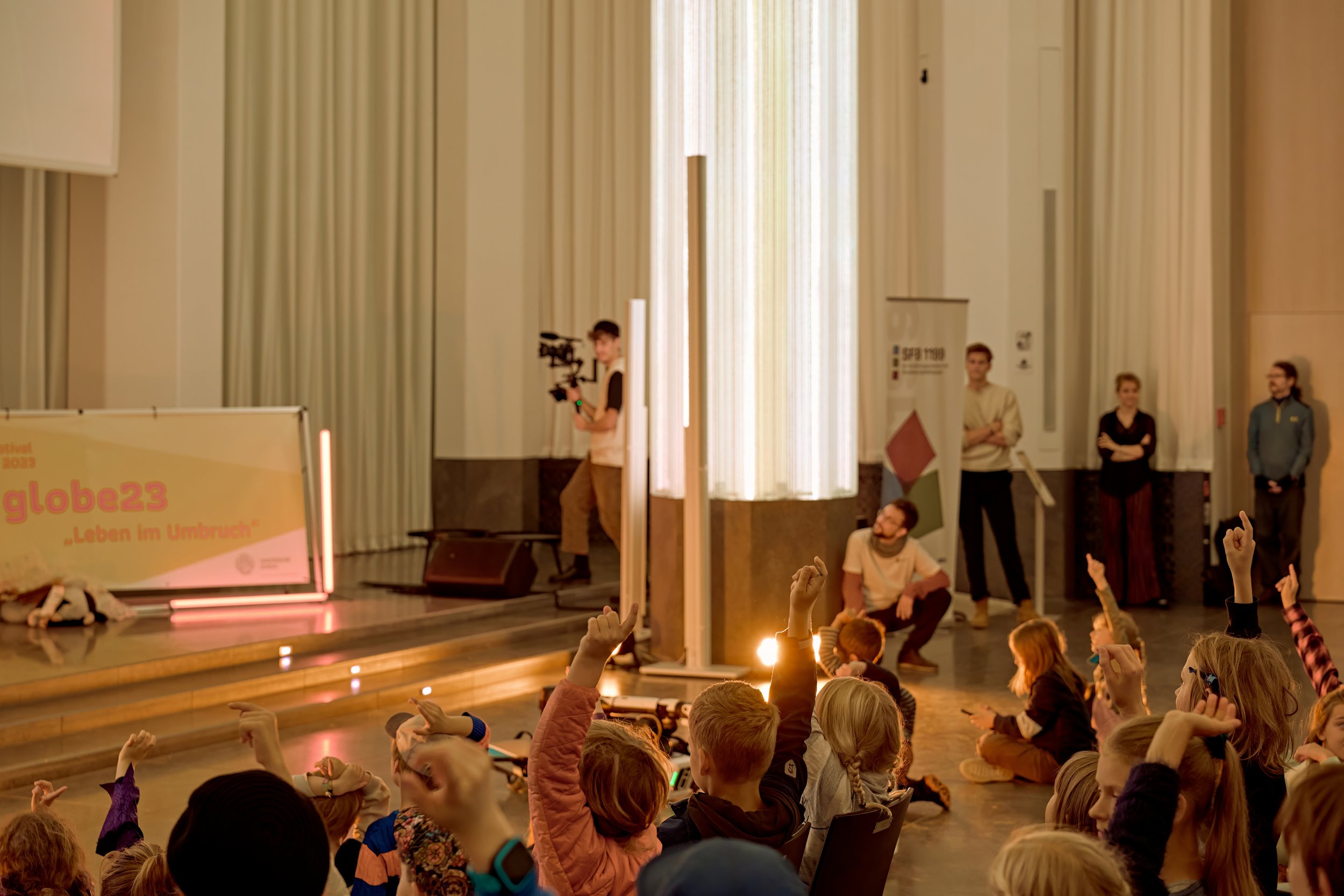 Kinder melden sich im Publikum. Foto: Florian Förster/Universität Leipzig.