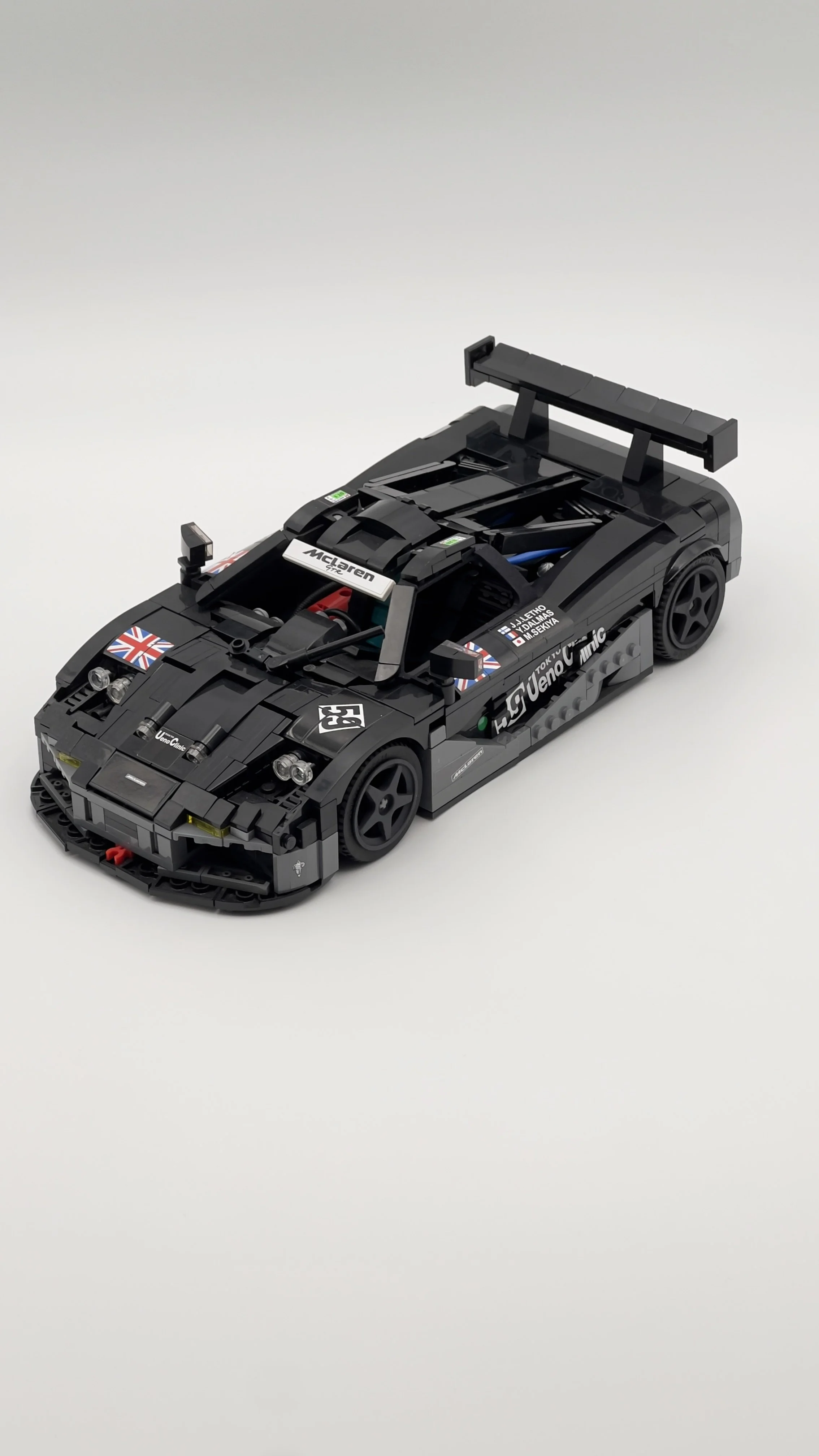 A detailed LEGO model of a black McLaren racing car with sponsor decals and a large rear wing.