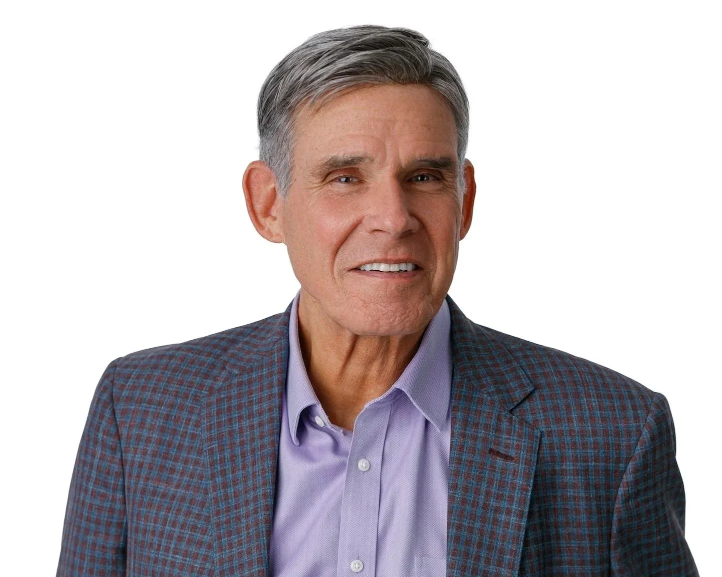 Eric Topol wearing a purple shirt and checkered coat in front of a white background.