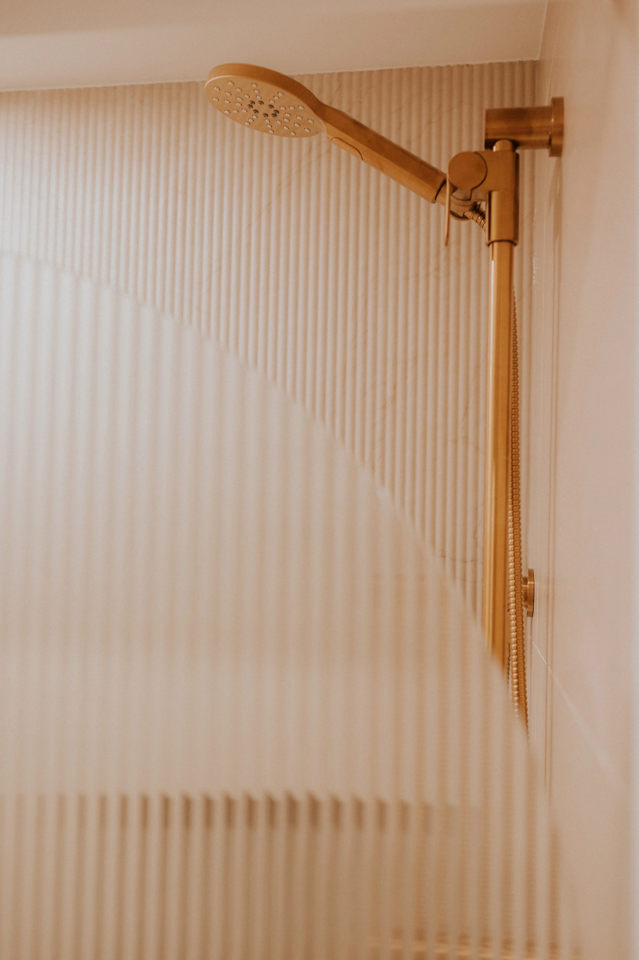Gold Shower Head and Textured Shower Tiles