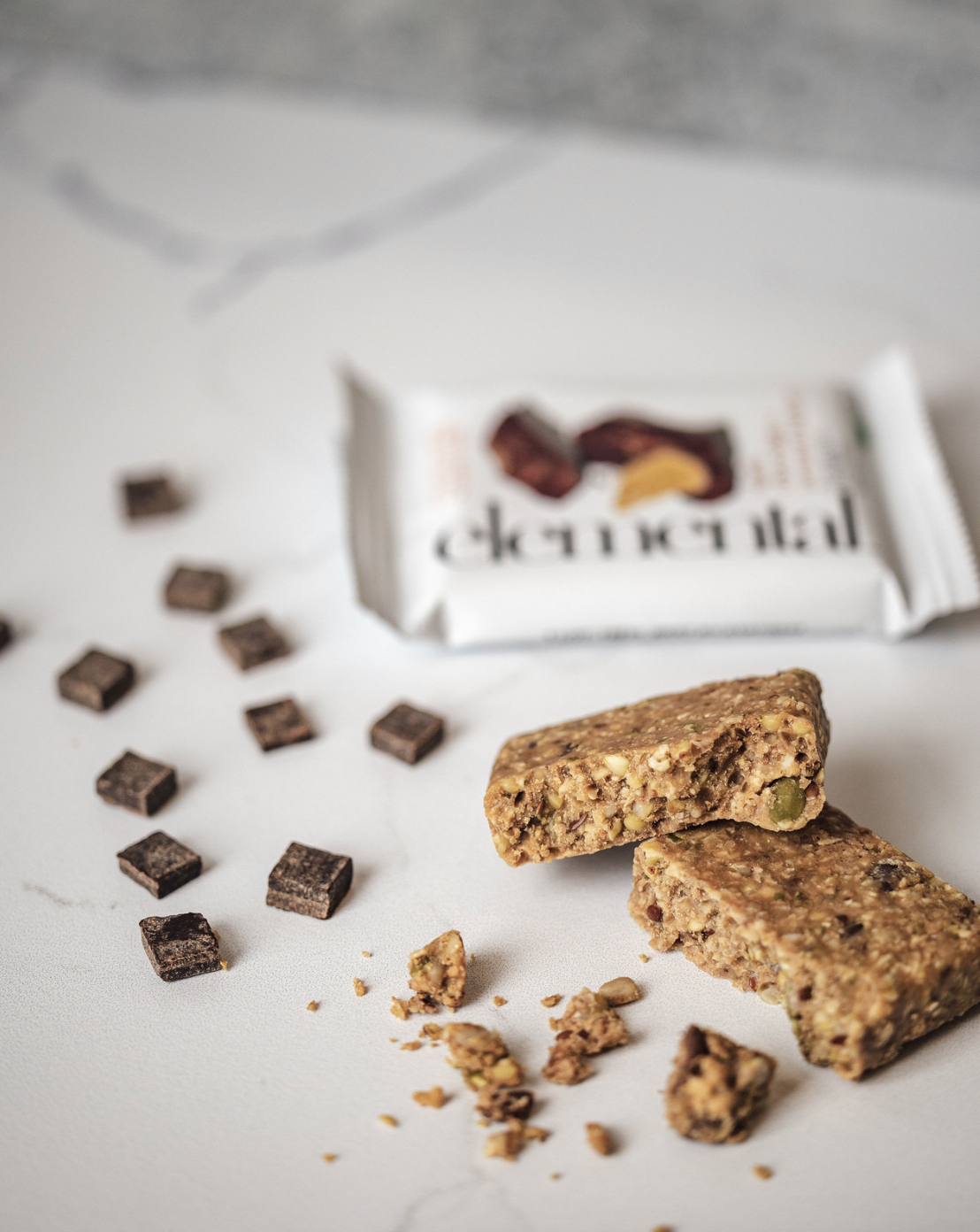 Person holding a small blue bowl of fresh strawberries outdoors on a sunny day.