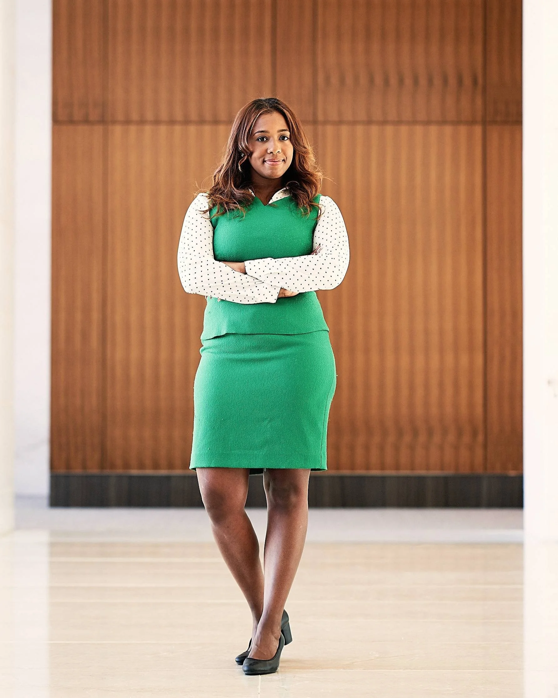 Full-length portrait of female executive standing confidently in a modern corporate interior.