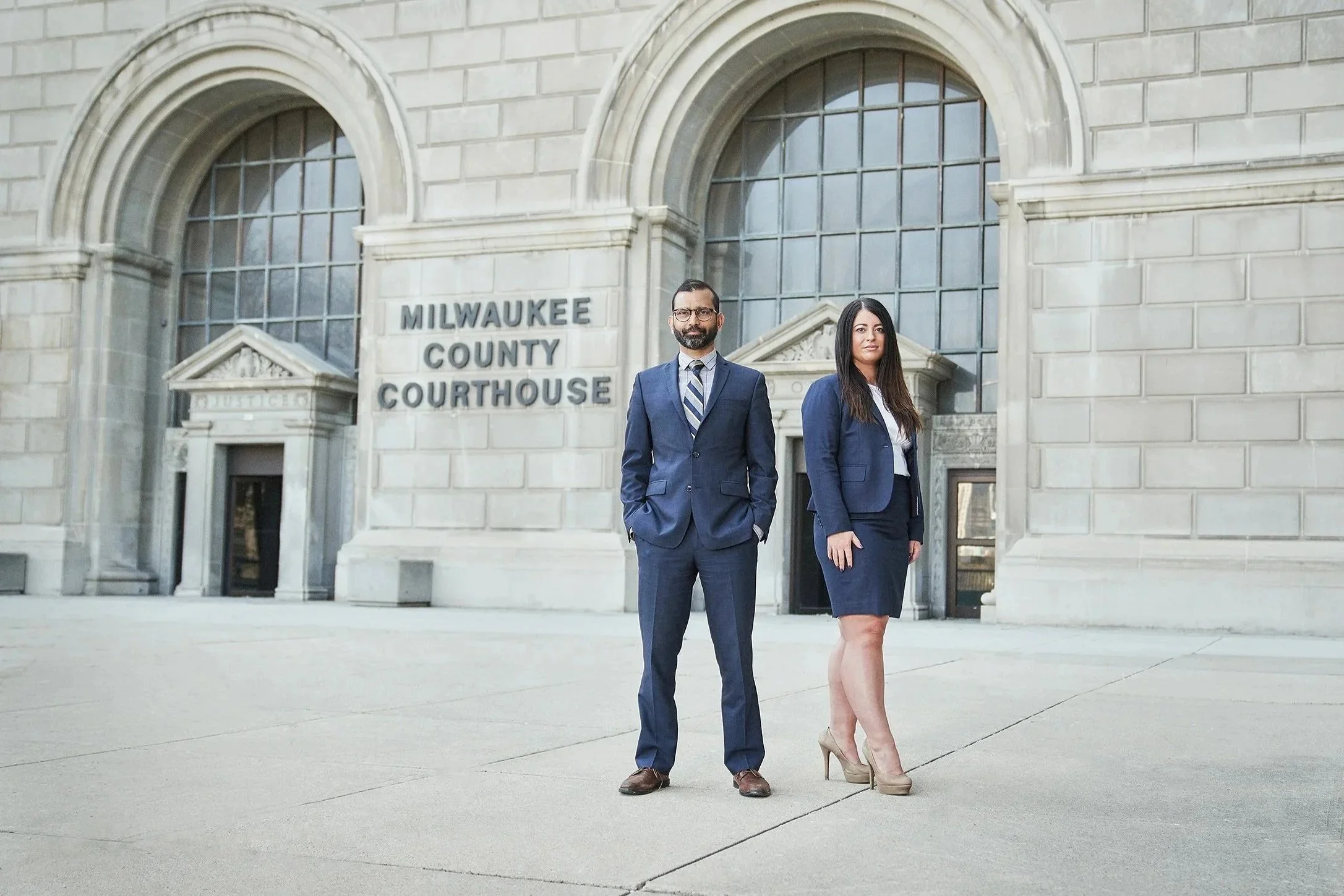Corporate portrait of attorneys from Ahmed and Associates standing outside the Milwaukee County Courthouse.