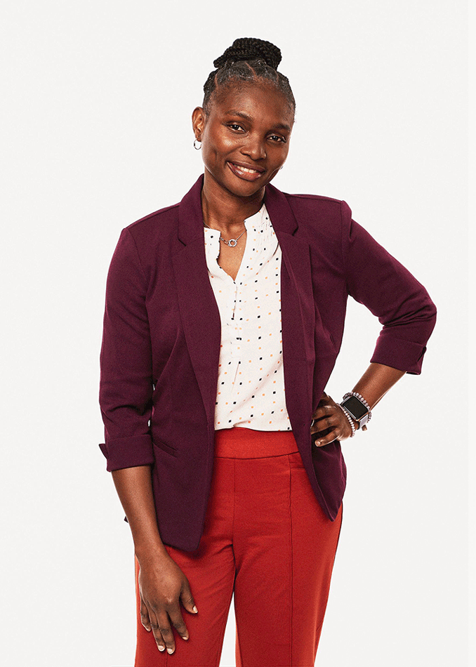 Professional portrait of a healthcare executive standing against a neutral studio background