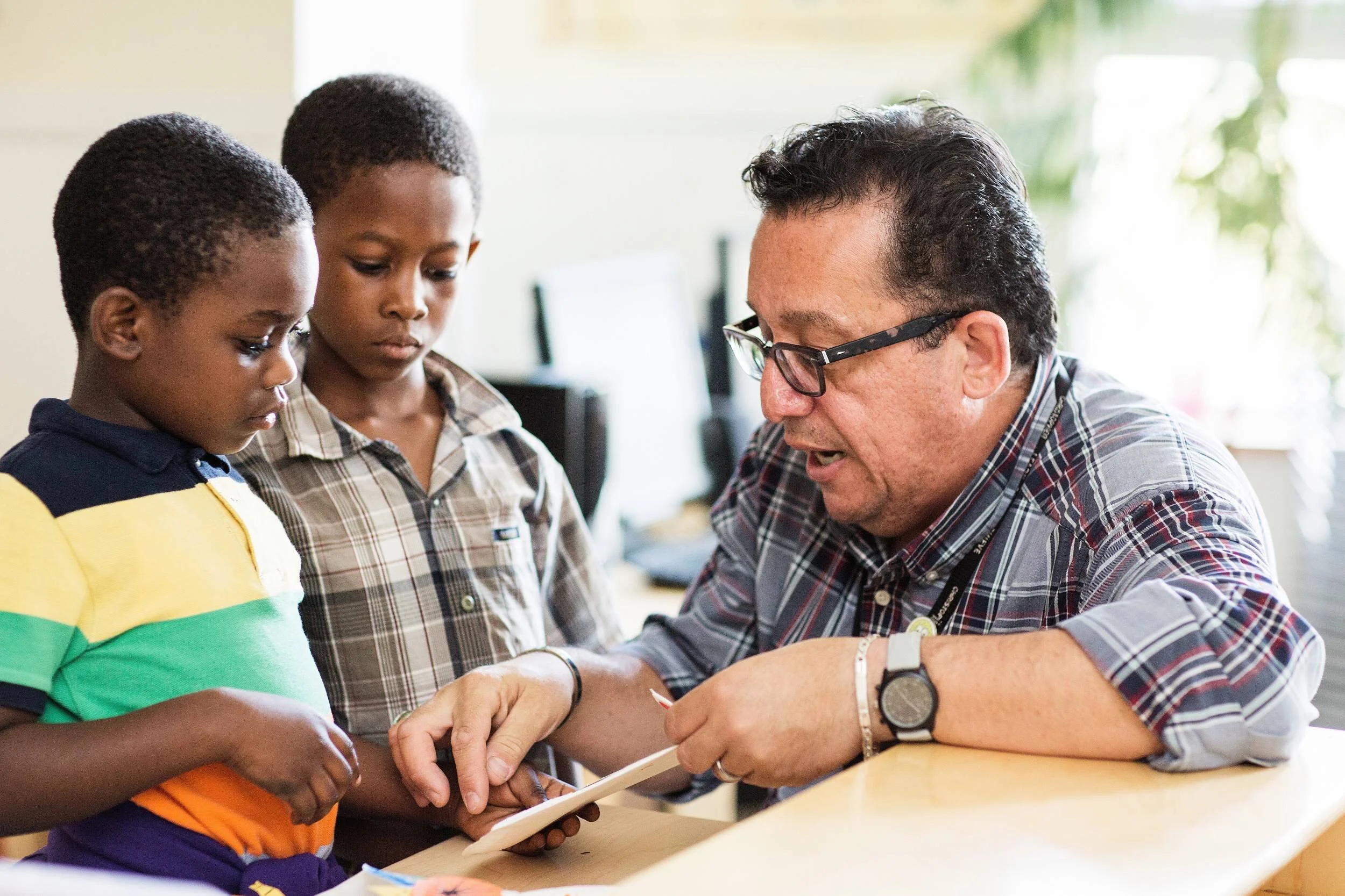 Mentor helping two young students with a learning activity during a Chicago afterschool program.