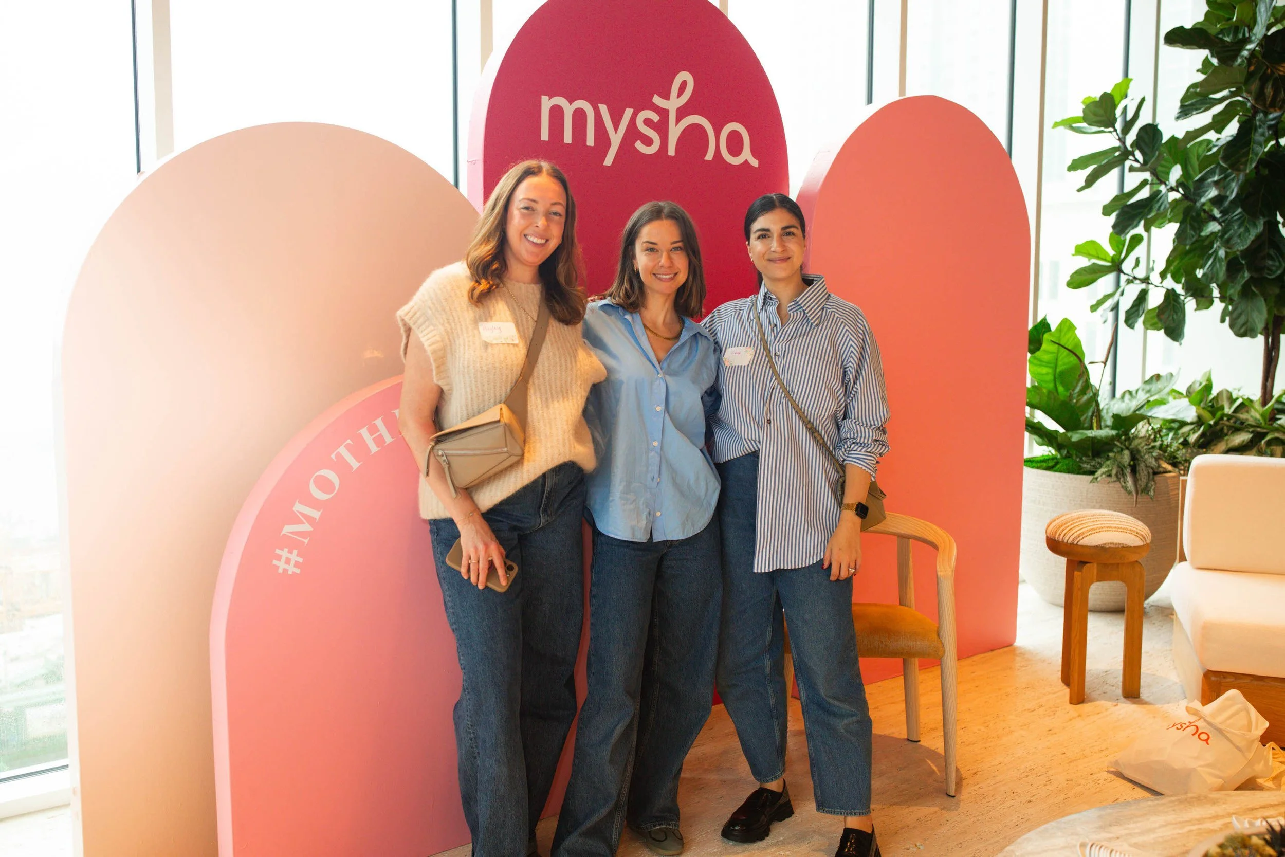 moms in front of mysha sign at local in person mysha mixer