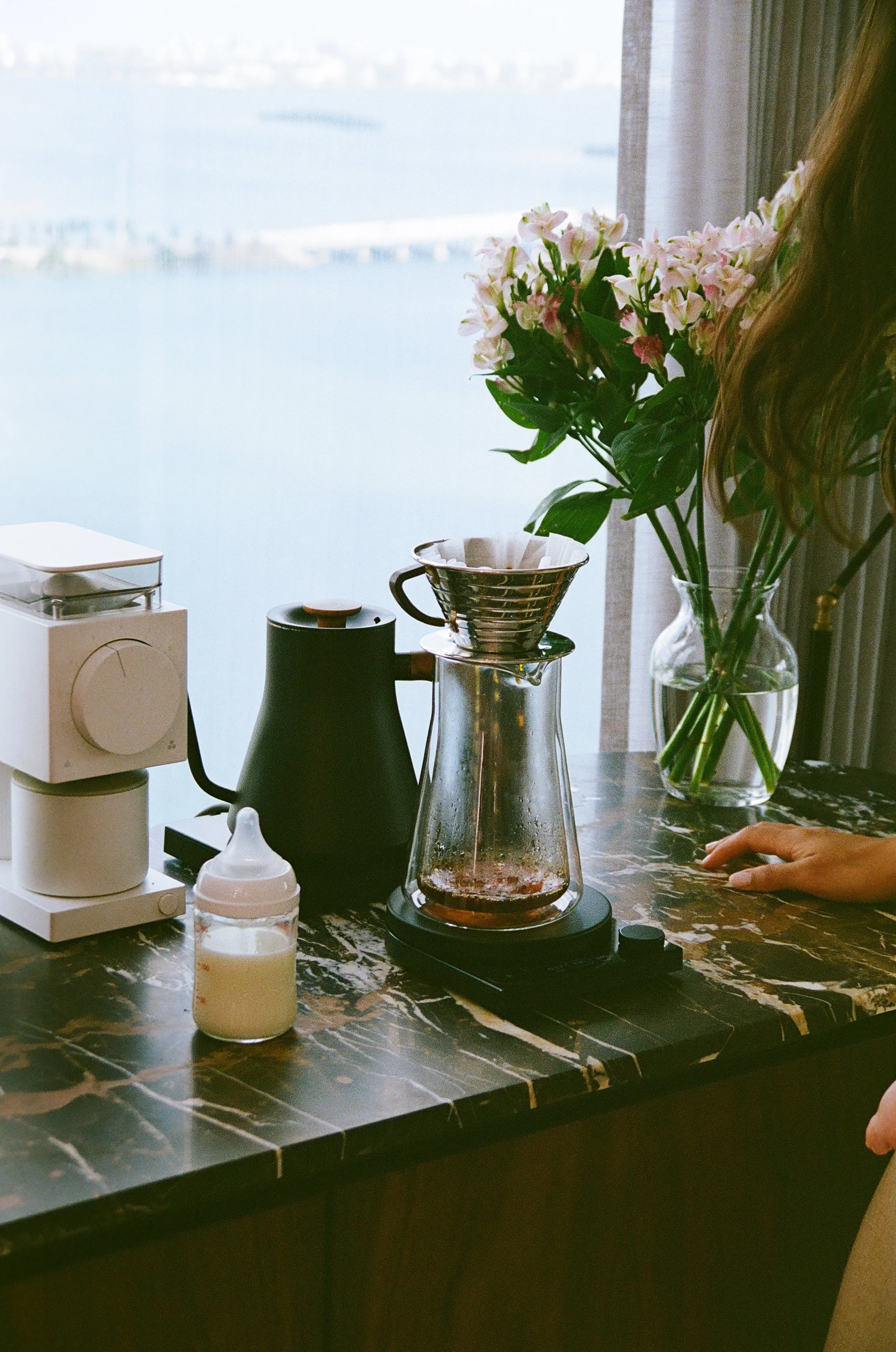 nyc mom making pour over coffee and getting baby bottle ready