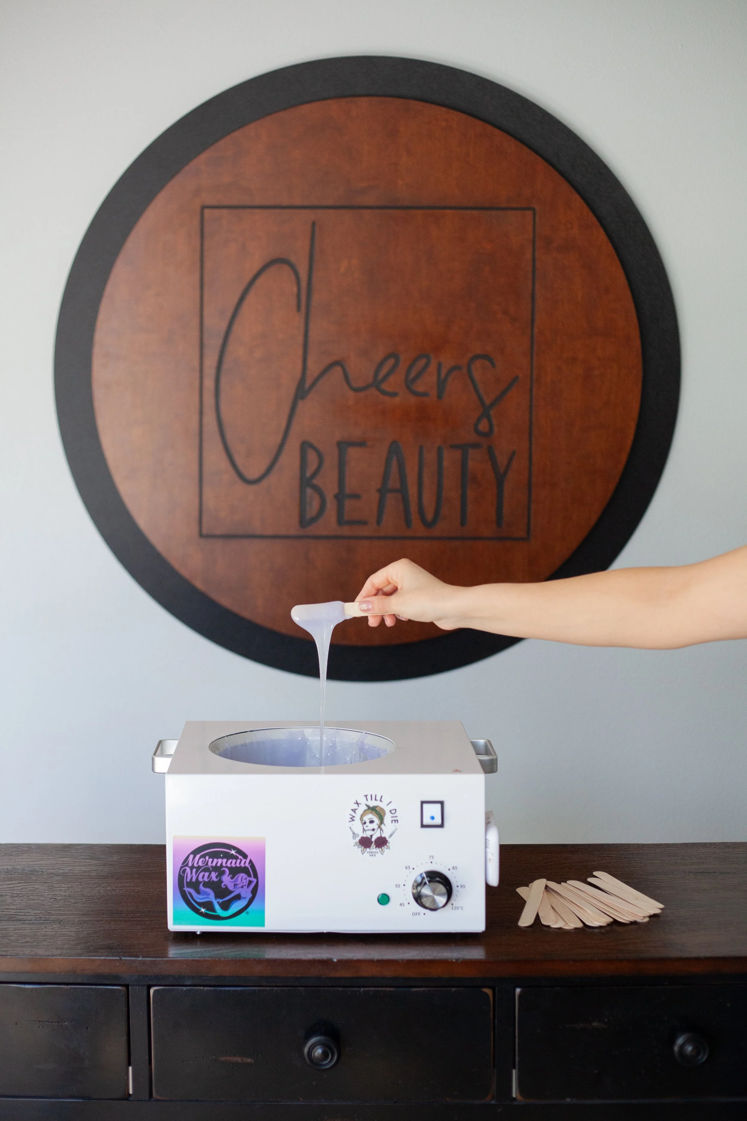 Cheers Beauty Sign and wax dripping into a wax pot at Cheers beauty