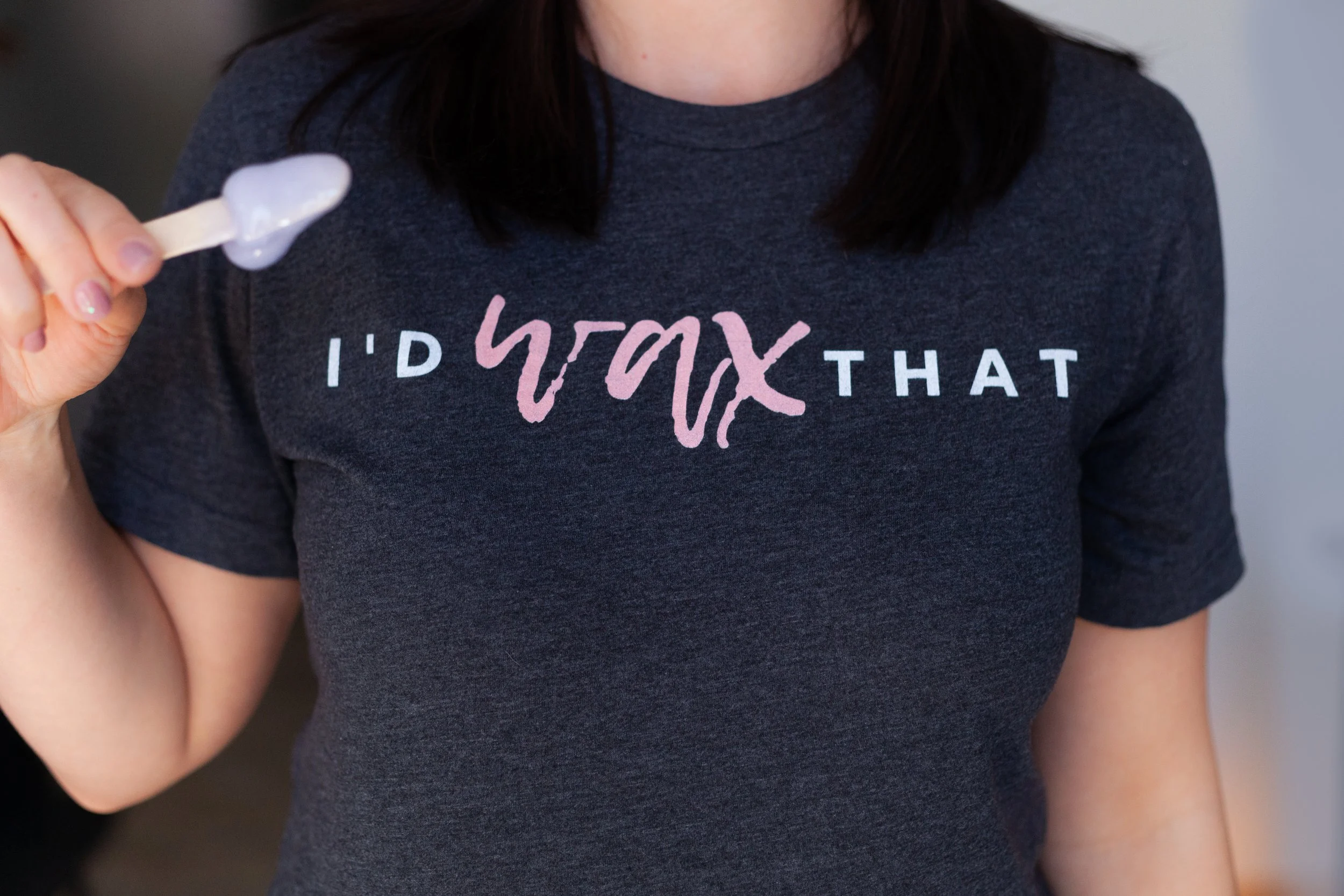 Wax Expert holding a wax applicator while wearing an "I'd Wax That" Shirt