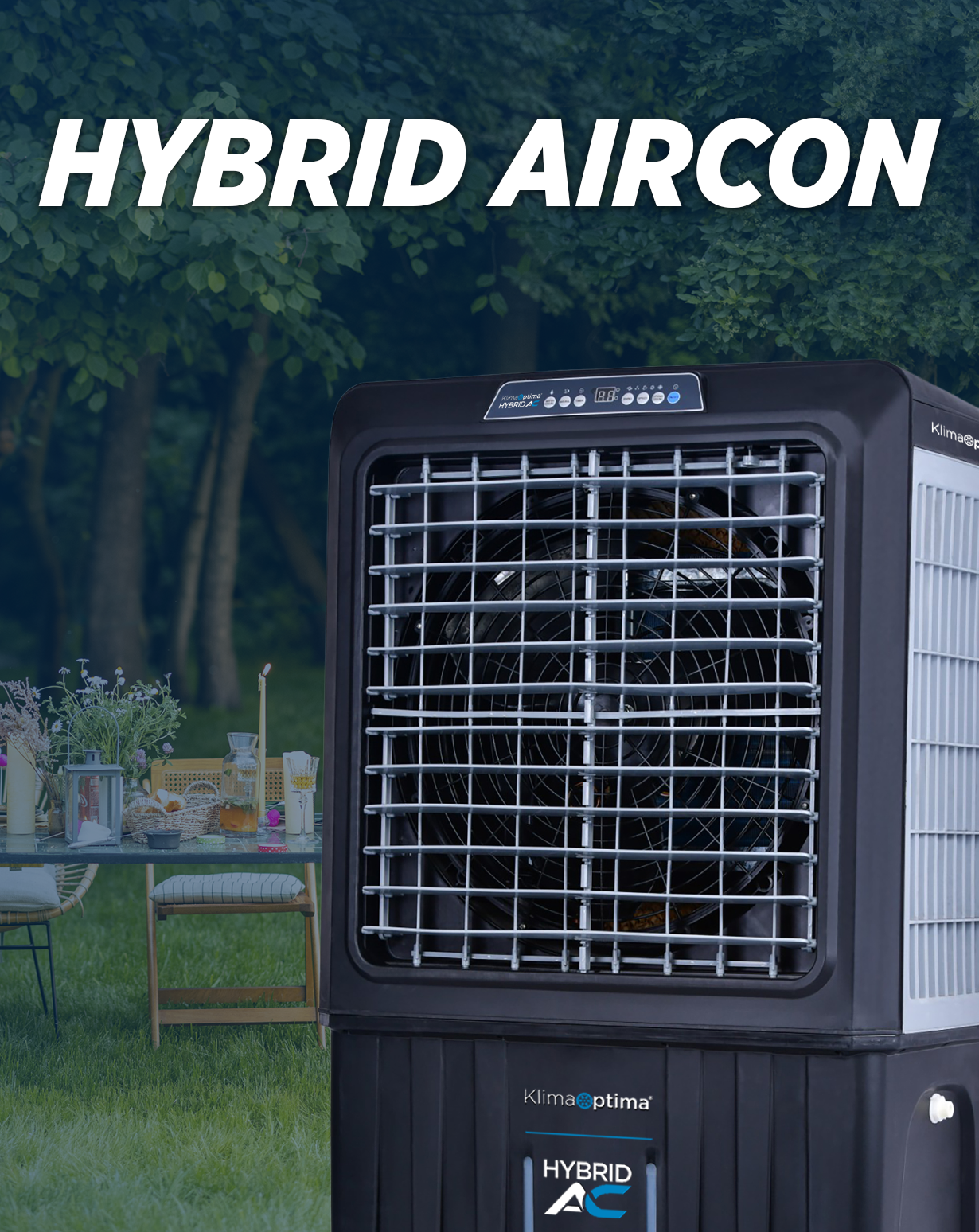 A black hybrid air conditioning unit outdoors on a grassy area, with trees and a table with chairs and flowers in the background.