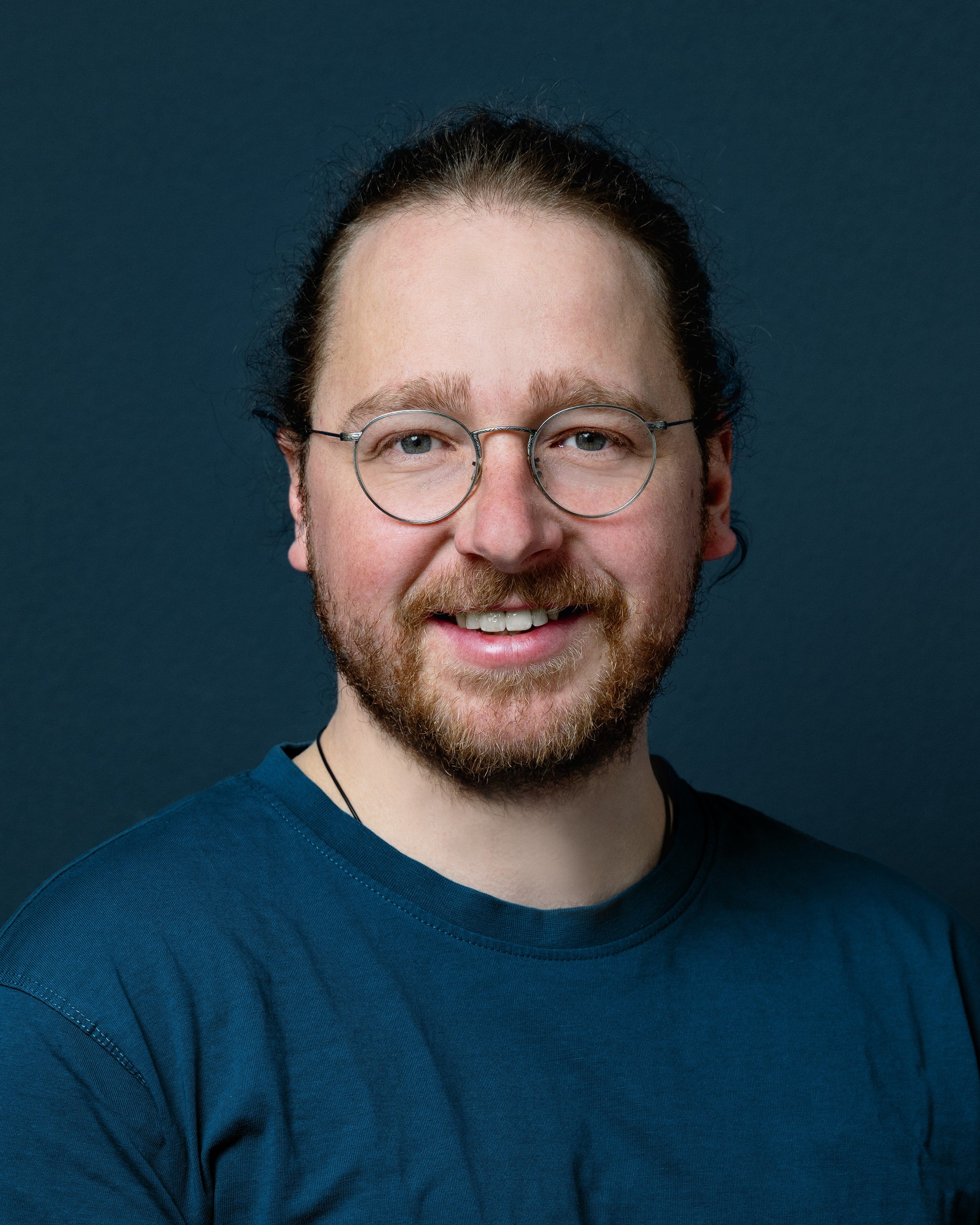 Portrait eines lächelnden Mannes mit Brille und Bart