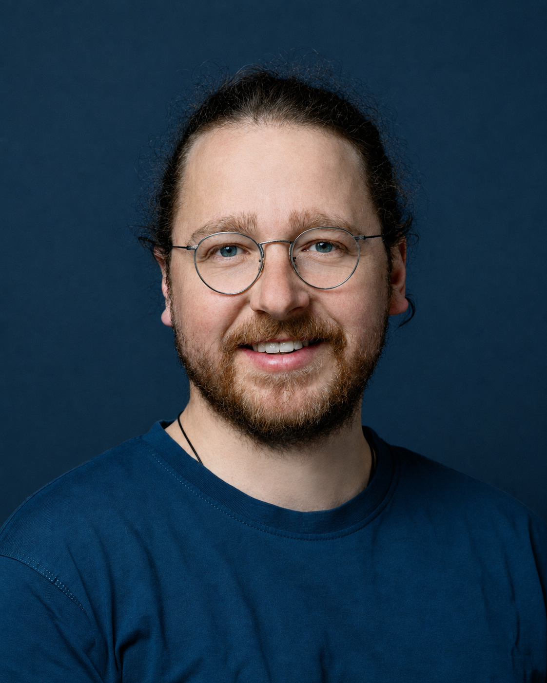 Portrait eines lächelnden Mannes mit Bart und Brille