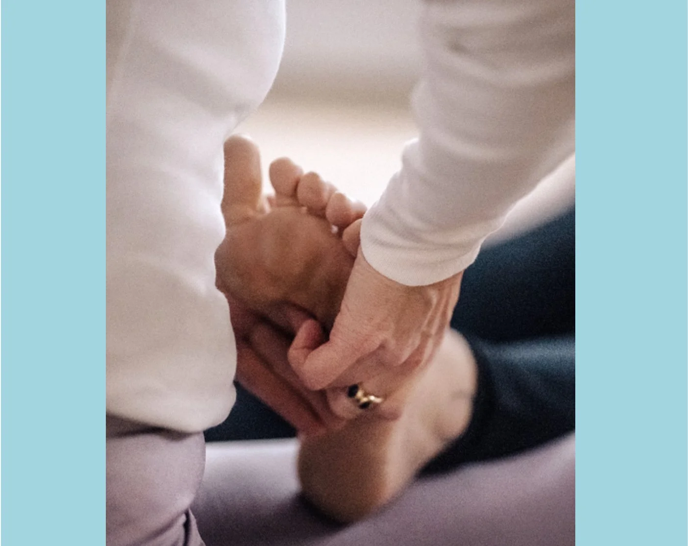 Ein Fuss bekommt eine Fussmassage von zwei Händen.