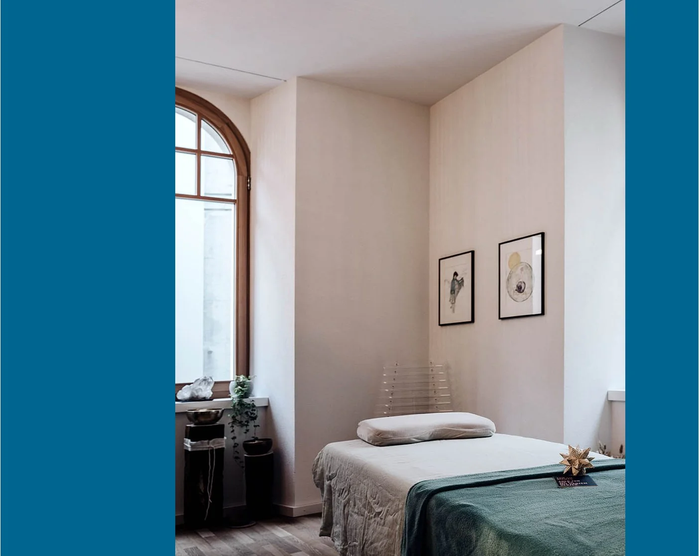 Schöner, ruhiger Praxisraum mit einer Liege und einem Kissen darauf.