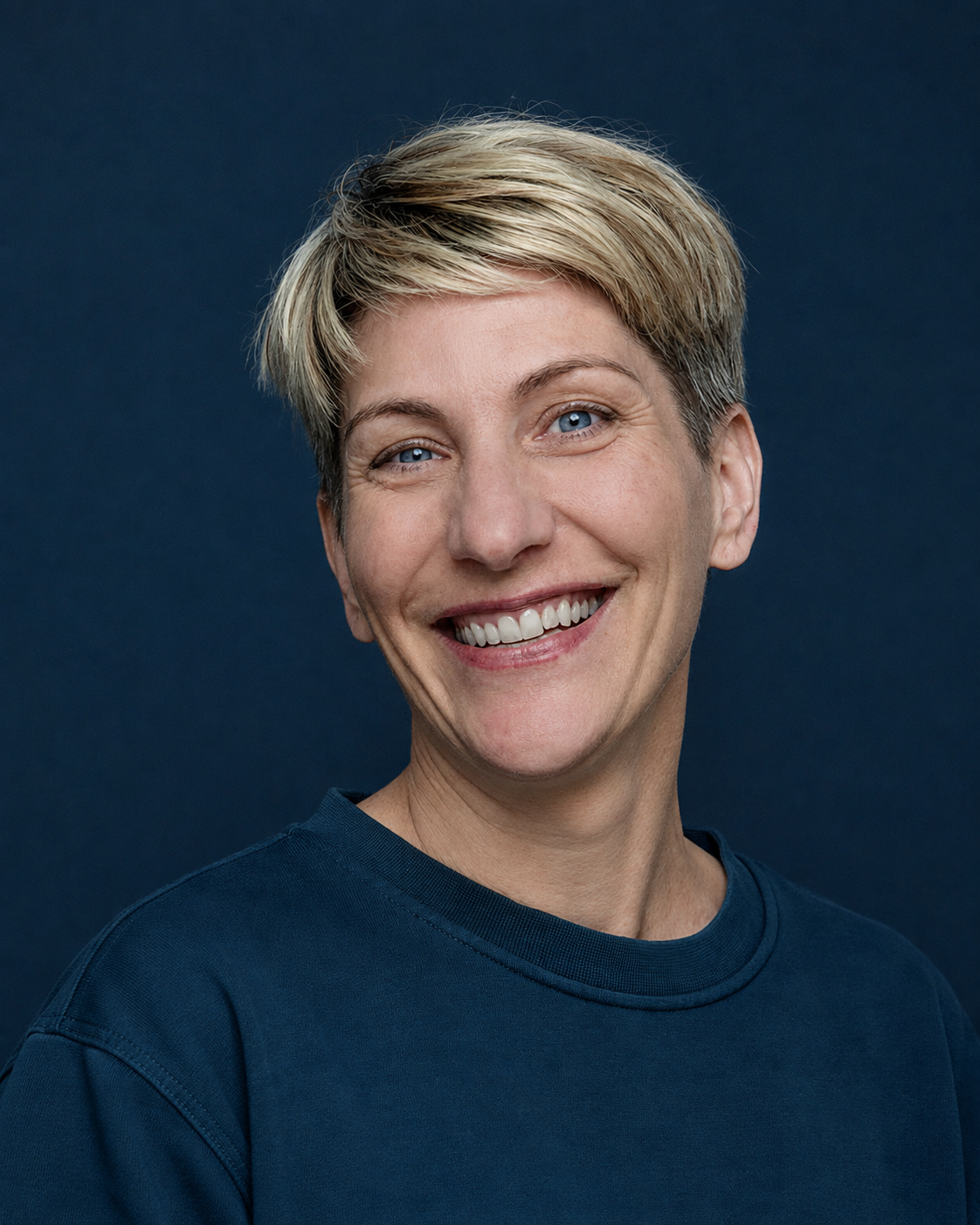 Portrait einer lächelnden Frau mit kurzen blonden Haaren