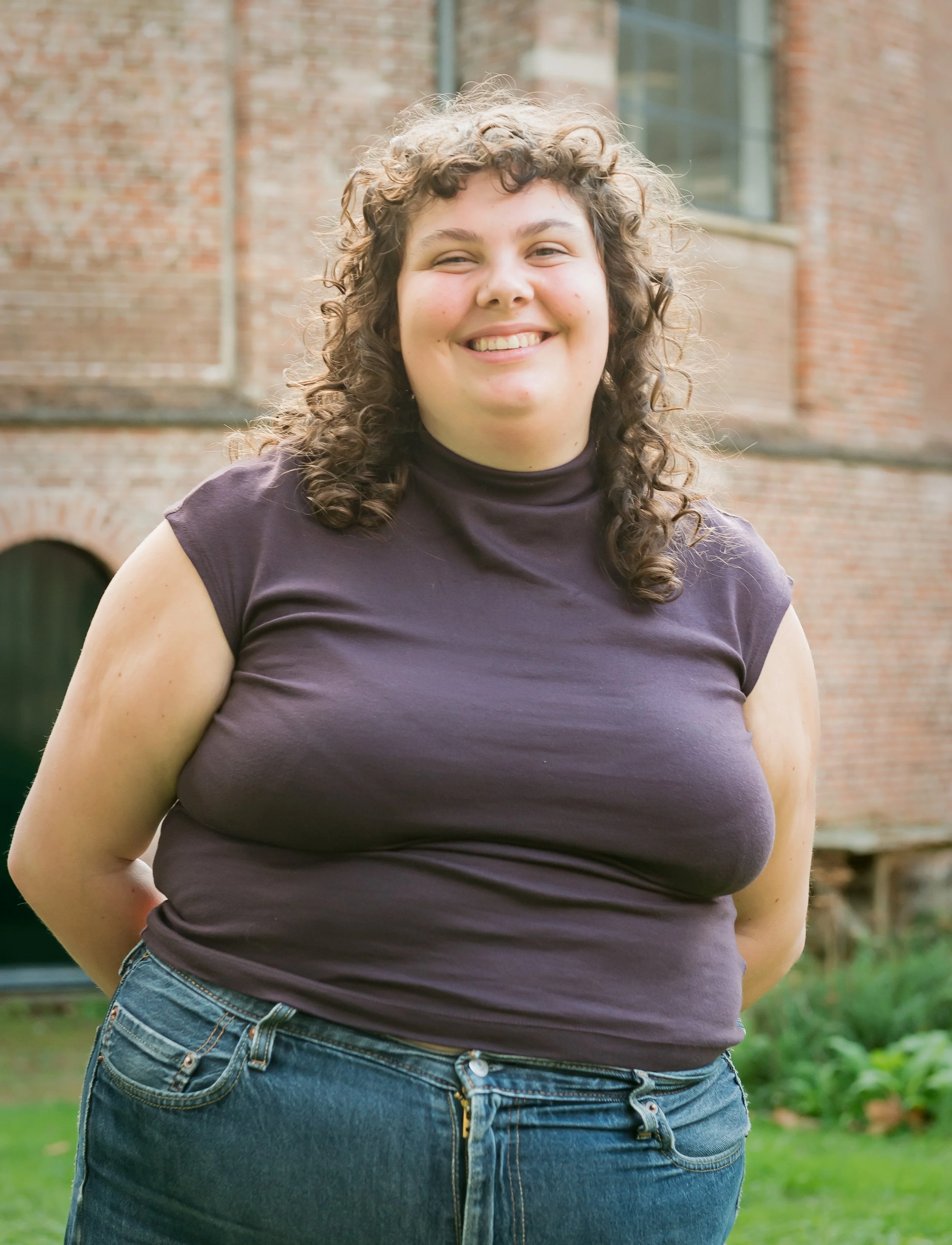 Woman standing in front of brick building.