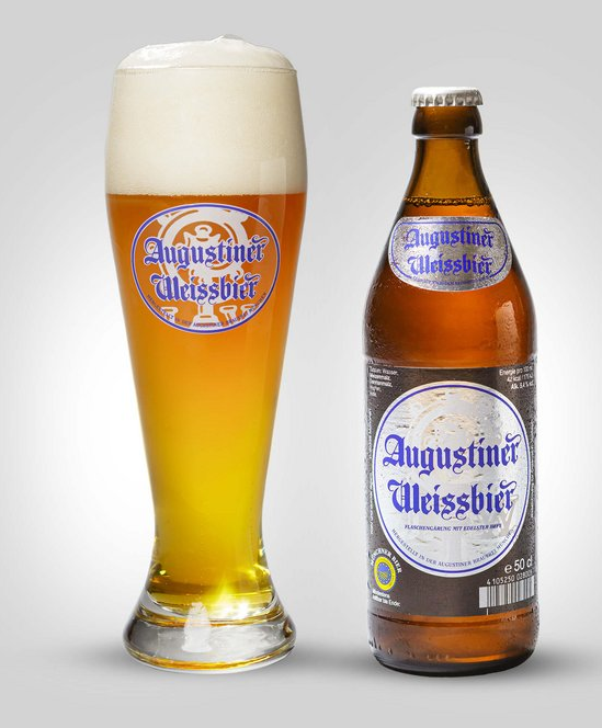 A filled glass of Augustiner Weissbier beer with a foamy head next to a beer bottle of the same brand on a plain background.