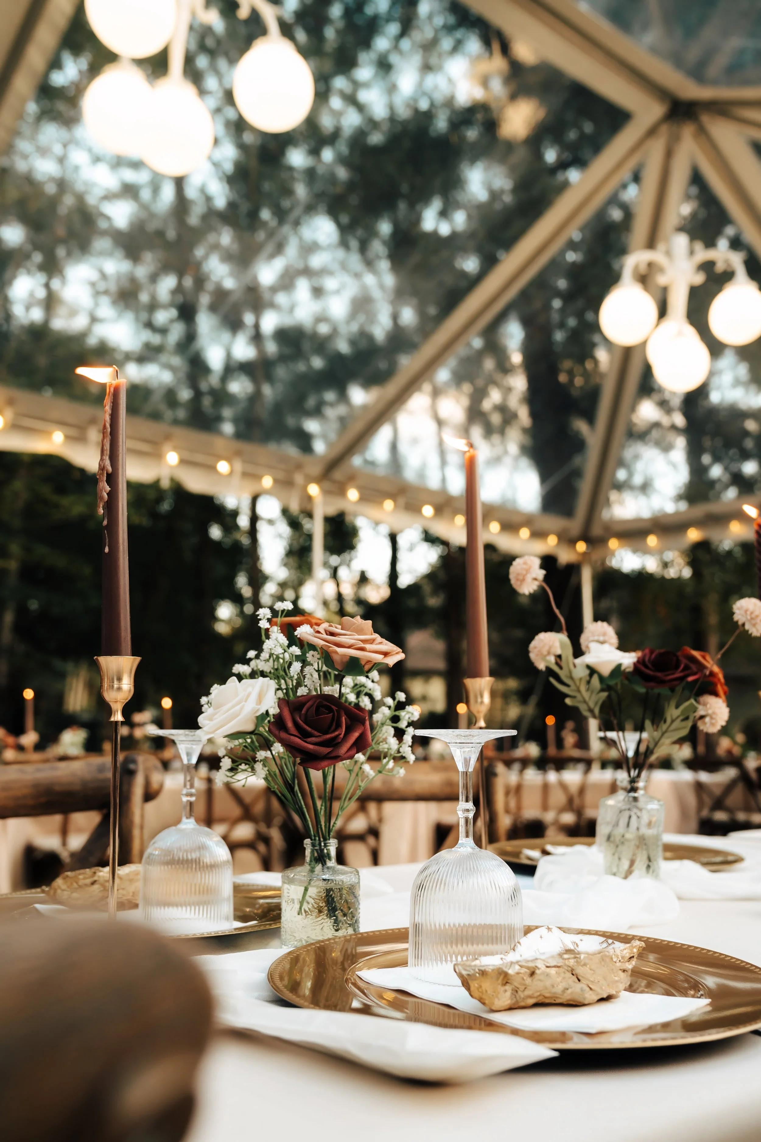 A dinner table with neutral flowers and glasses at a wedding