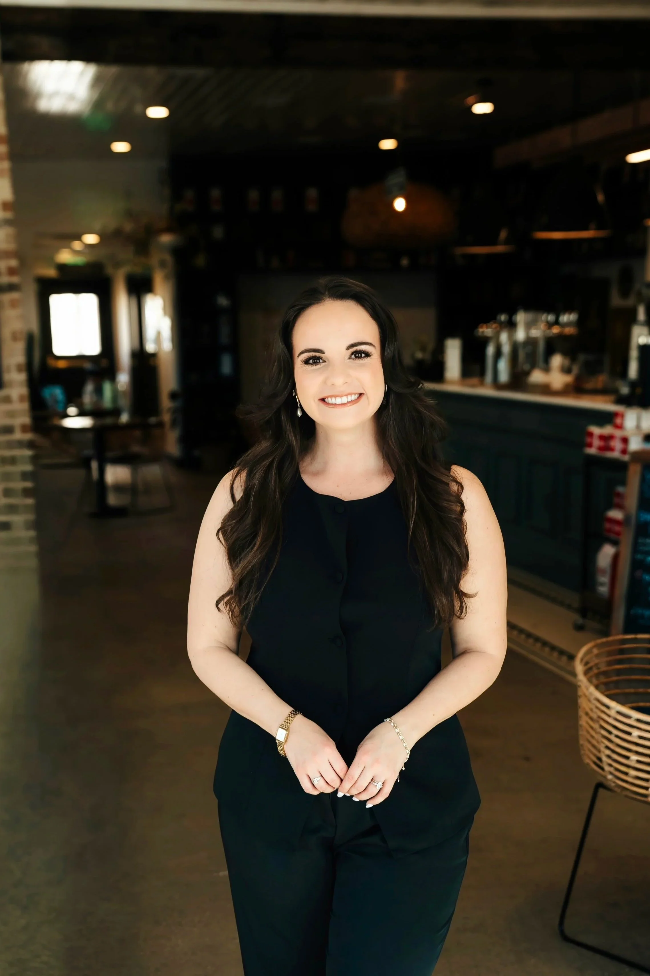 Woman in black jumpsuit at a coffee shop