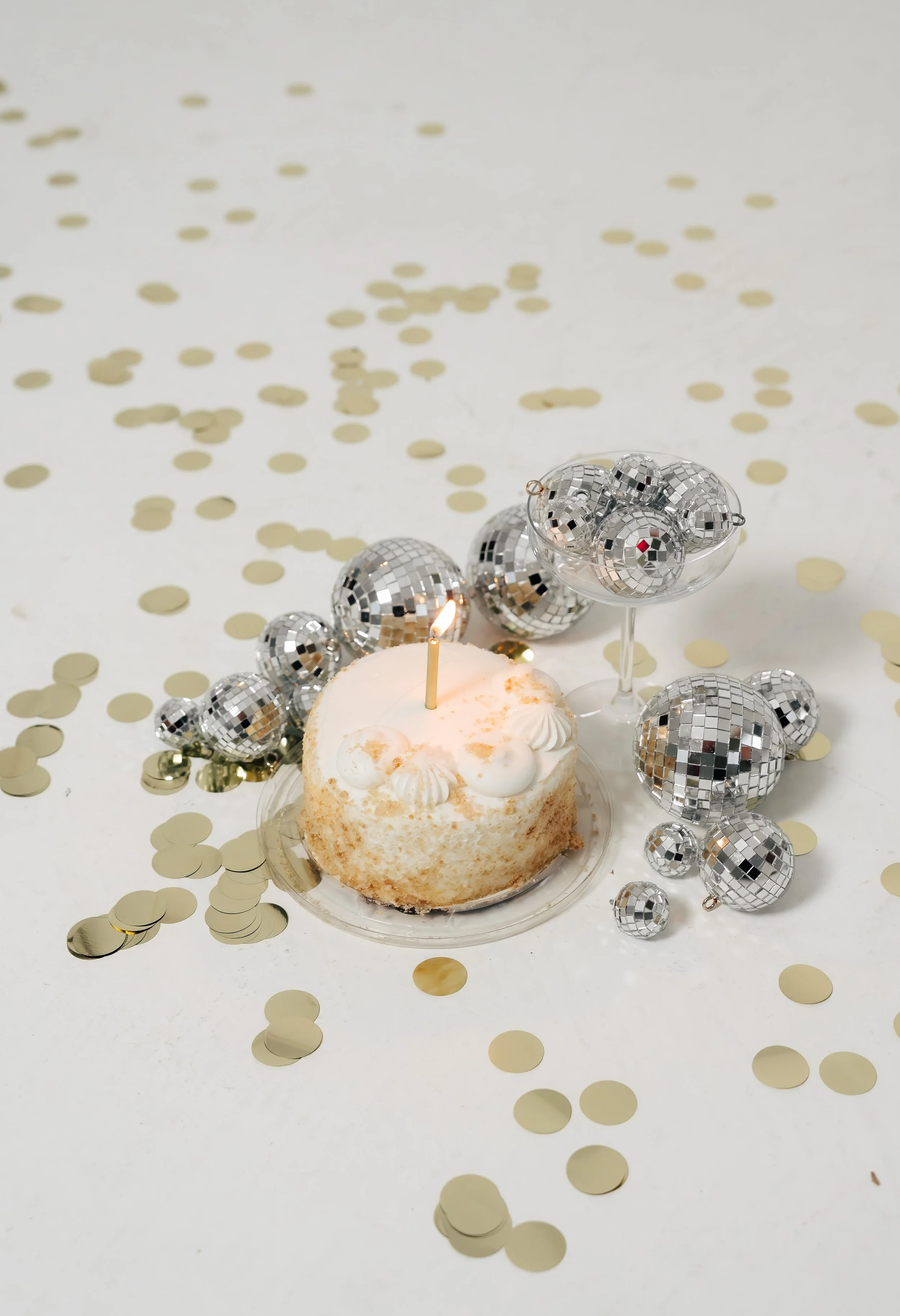 White birthday cake with gold confetti and disco balls