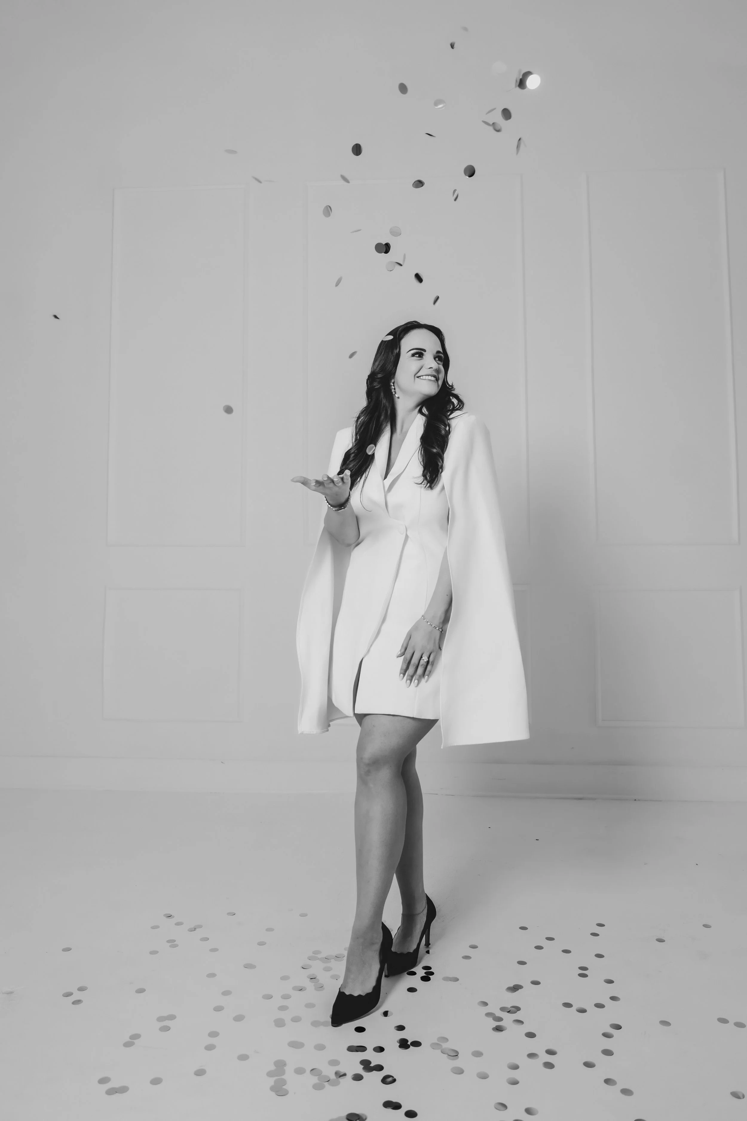 Woman in a white cape throwing glitter confetti