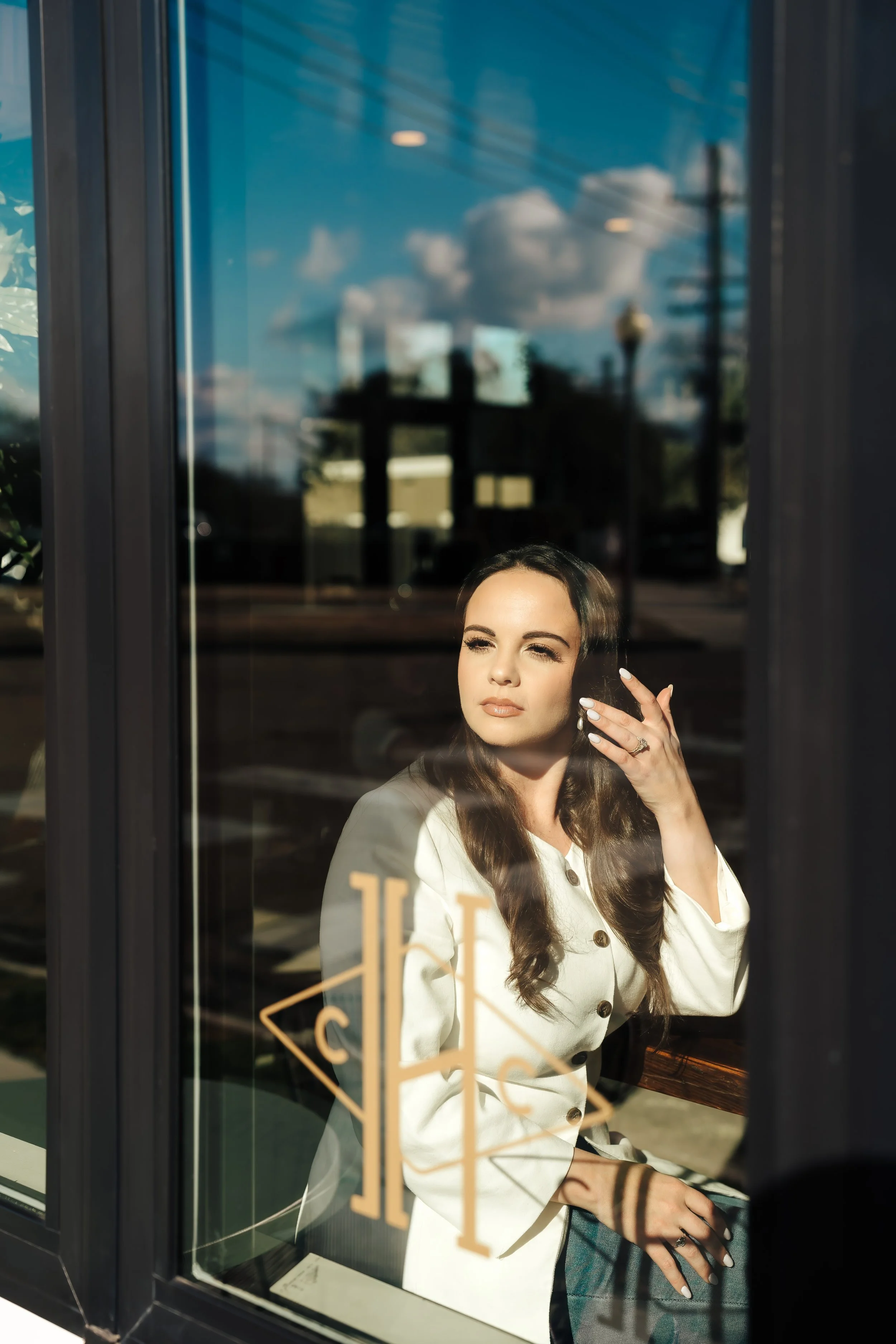 Woman with serious expression peers through storefront window