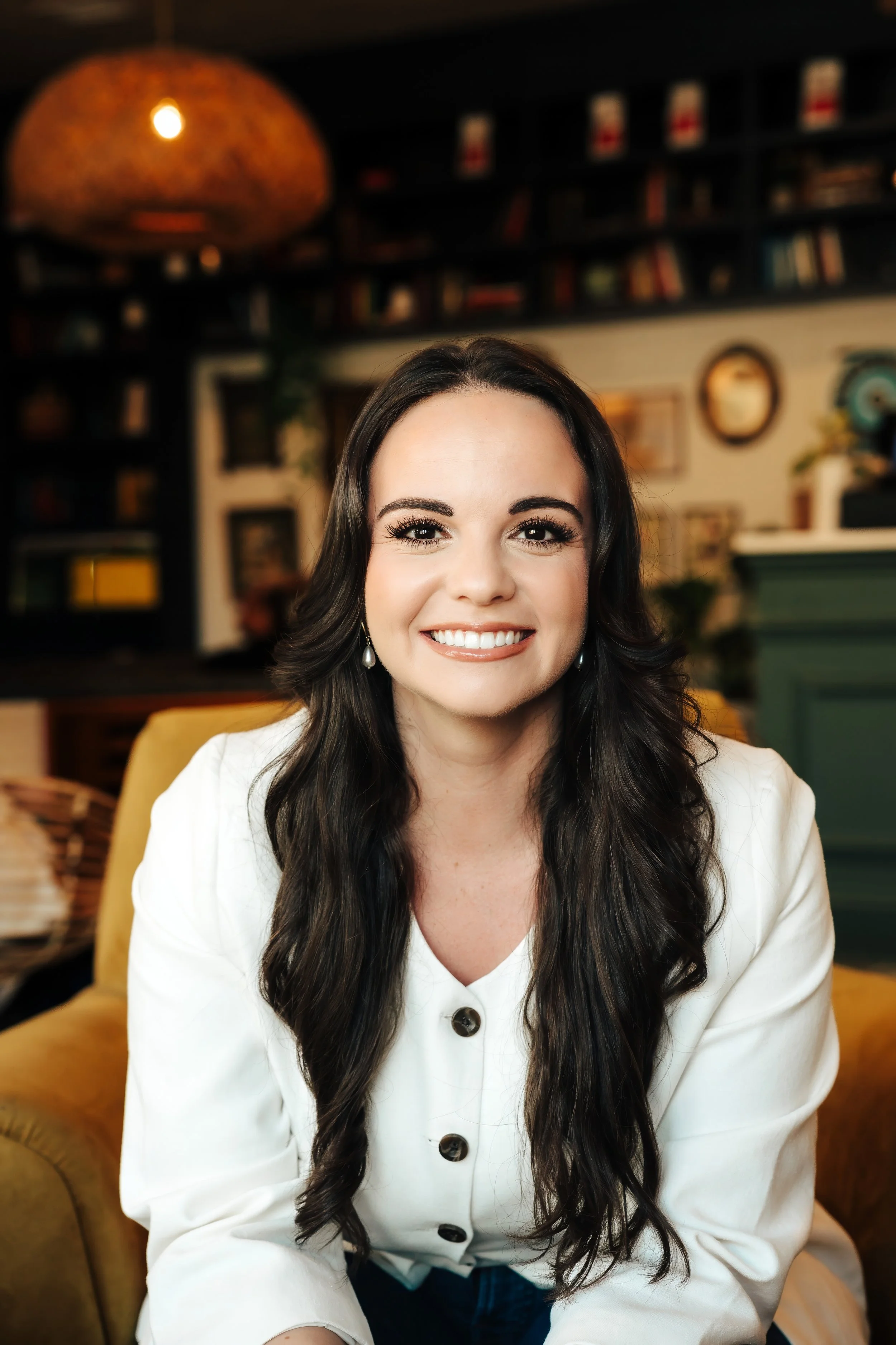 Close up of smiling brunette woman in white button up jacket