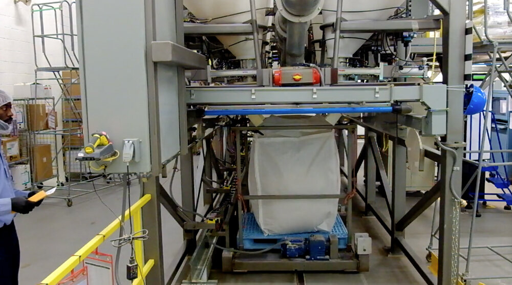 Batching system scale cart with bulk bag indexes under the dispensers to receive portioned raw materials.