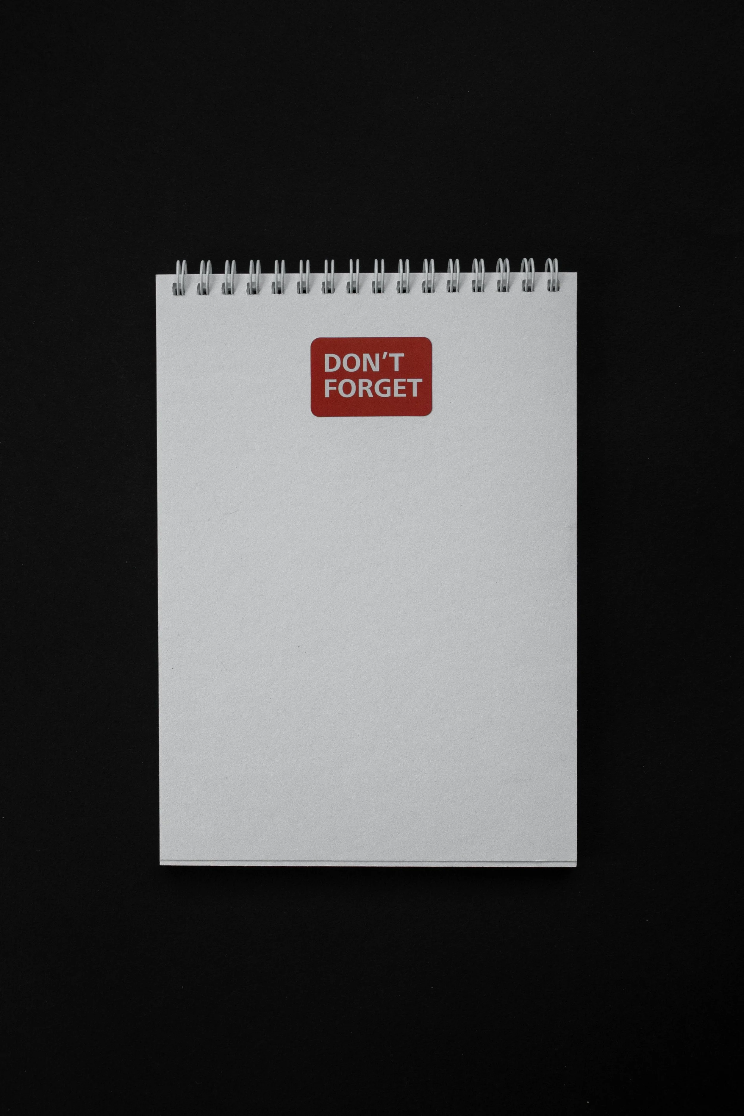 a note pad with a red sticker reading "don't forget"