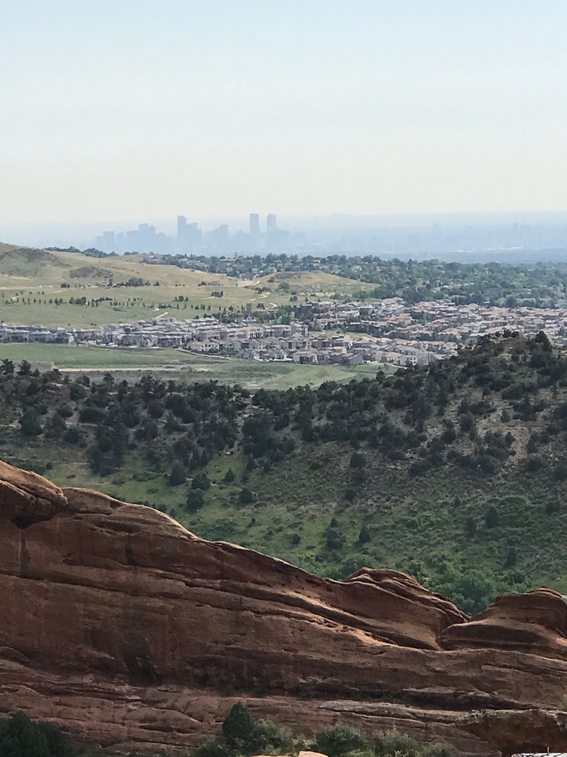 Red rocks and rolling hills - that's Denver in the background!