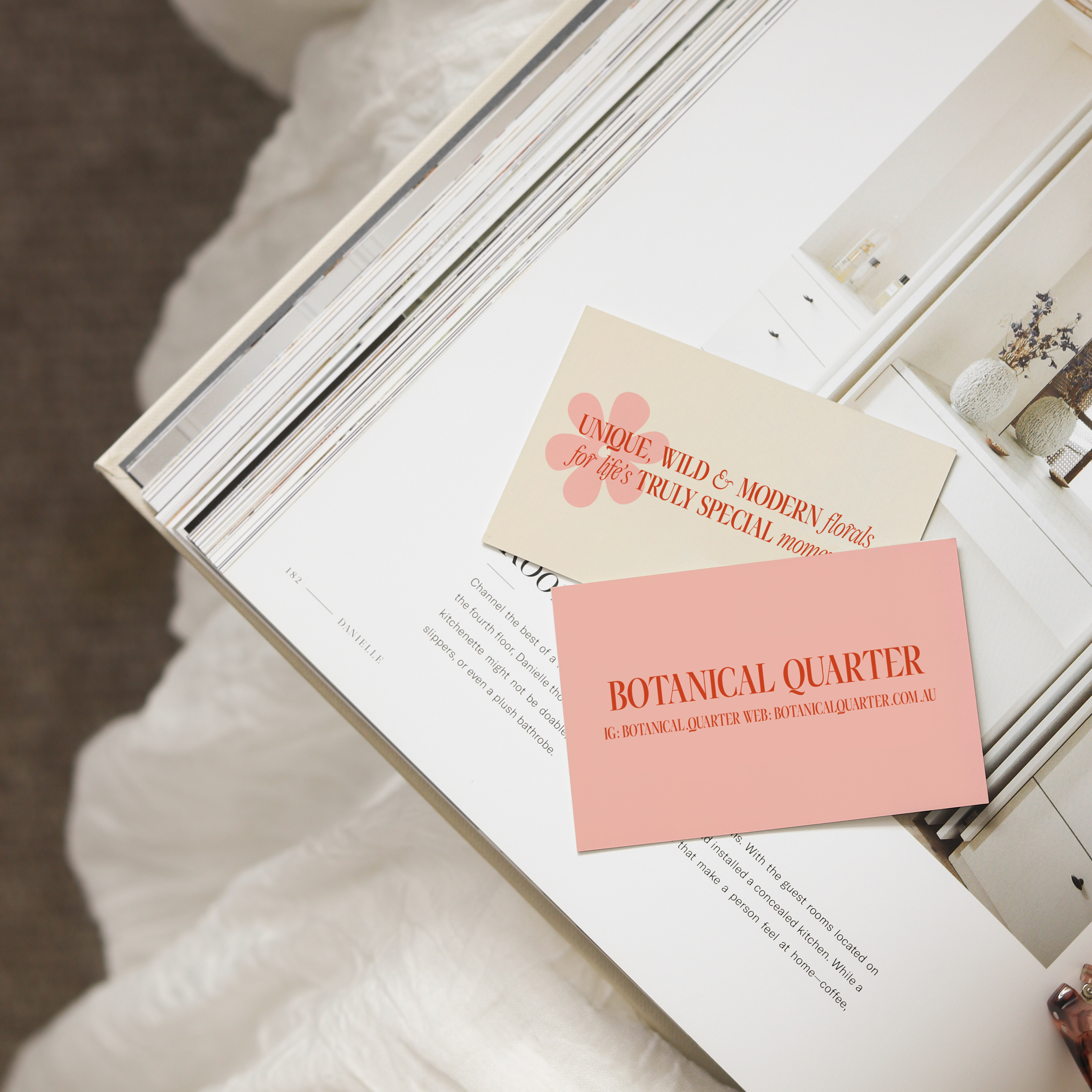 Business cards for "Botanical Quarter" on top of an open book, showcasing floral and contact information.