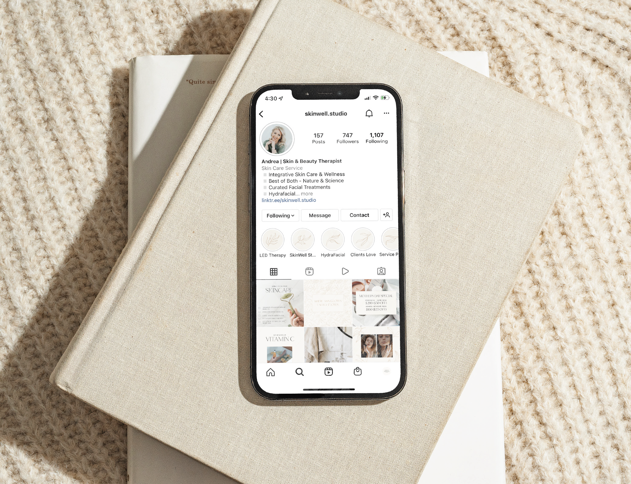 Smartphone displaying an Instagram profile for "skinwell.studio," placed on a stack of beige books with a textured background.